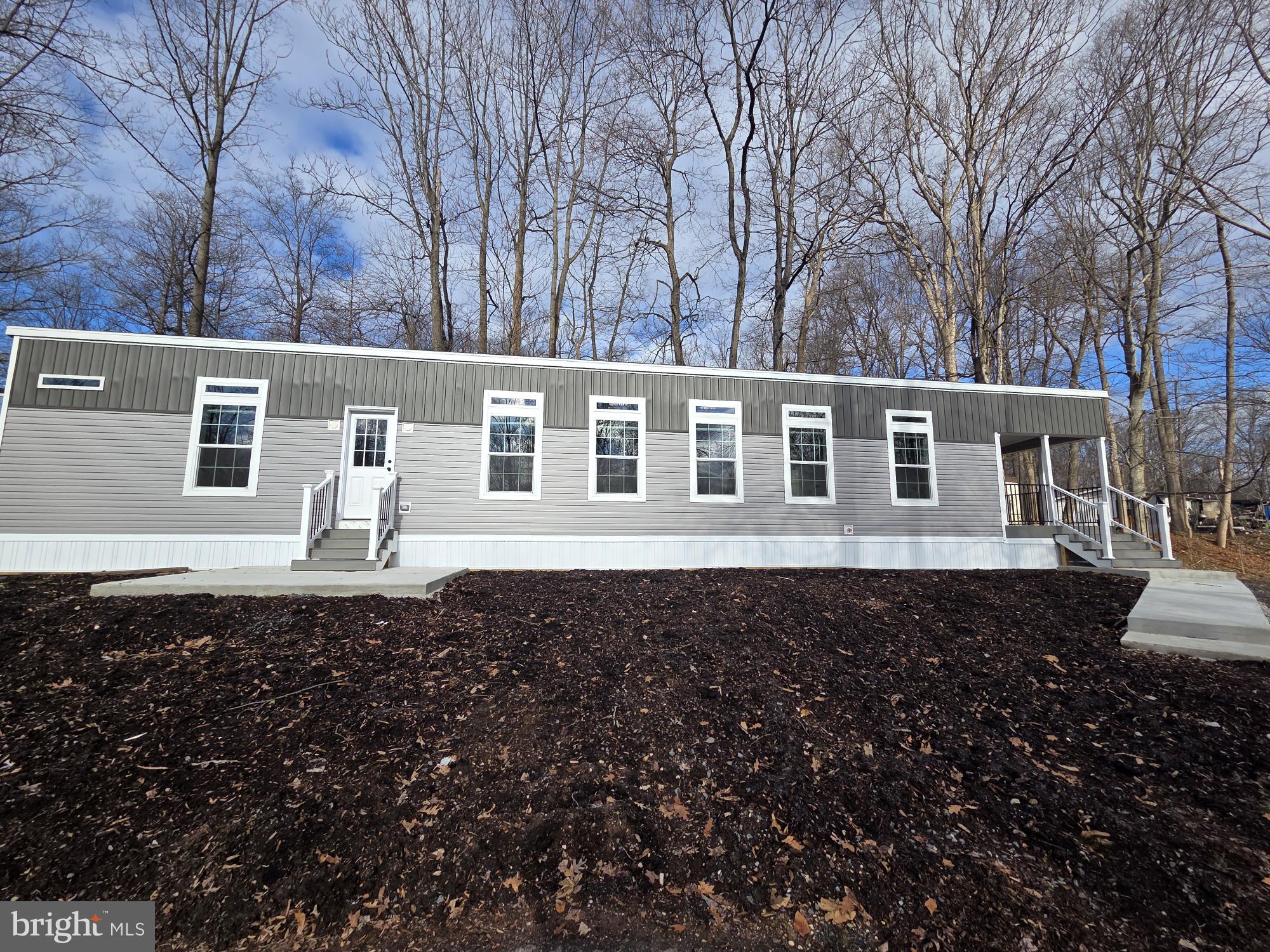 New 2 bed 2 bath home with covered porch.  Open living room and kitchen area with a large walk-in pantry, stainless steel farm sink, dishwasher, microwave, refrigerator and range.   The primary bedroom has a full bath with a large walk-in closet.  Bedroom two is at the opposite end of the home with another full bath.  The home comes with central air, an 8’ x 8’ shed and a 1 year manufacturer warranty.  The $ 991 monthly land lease includes 1500 gallons of water/sewer use, the pool, mini golf, chip and putt, fishing ponds and use of the community pool for private functions. Park approval required.