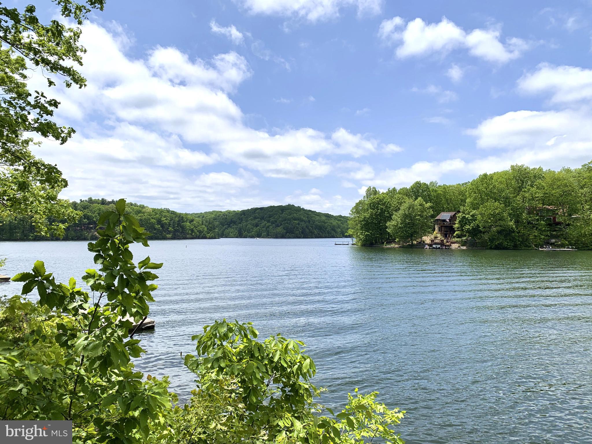 Rare waterfront living! Enjoy nearly 100' of direct water frontage and dock from this totally renovated spacious chalet ready for summer fun! Perfectly nestled above a quiet deep water cove, this charming Tudor style waterfront chalet offers sweeping views of Lake Holiday from 3 sets of outdoor decks. 3 finished levels and over 2100sf of space offers plenty of room to roam, plus an oversized 2-car garage and extended driveway for lots of guests! Enjoy reclaimed hardwood floors, all new kitchen with SS appliances, all new custom tile baths including a main level full bath, an impressive brick fireplace with mantle in the spacious family room, and a wall of new sliding glass doors offering serene views of the lake. The upper level has a 3 bedrooms with new carpet that share a brand new hall bath with custom tile and new quartz vanity. The large rear bedroom has new sliding glass door to a private veranda and tons of side storage.  Bright kitchen has newly painted cabinets and hood vent, new Quartz countertops and breakfast bar. A huge open-shelf pantry lies just off the kitchen, plus new Quartz wet bar and entrance to the garage.  Walk-out Finished lower level features a large rec room with new carpet, den with dual closets, and en suite full bath with new custom tile bath, utility room with new washer & dryer. The Primary Bedroom has new carpet, new bay window, and gorgeous newly renovated bathroom with new Quartz vanity with dual sinks, custom tile shower with seat and rainfall shower head, plus an enormous walk-in closet.  All new decking on 3 levels affords sweeping lake views, plus a lockable outdoor storage room for all things water sports! The brand new dual sliding glass doors to the large patio offer unparalleled waterfront views of the incredible sunsets on Sunset Circle! 

Beyond your own private dock, the gated Lake Holiday community offers residents wonderful amenities and activities. Enjoy boating, kayaking, paddle boarding, and fishing in the magnificent 240-acre lake, plus 3 sandy beaches for swimming, a large clubhouse with fitness center and many social events, tennis, trails, a fantastic dog park, a marina with 156 boat slips, and a surface storage lot for your boat for the winter. The July 4th fireworks display is really a sight to see. Life is better at the lake!