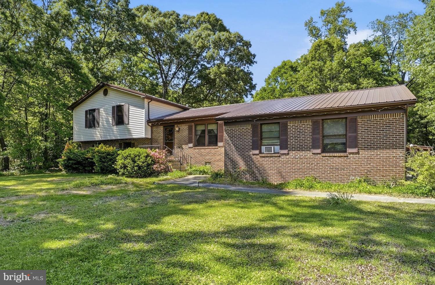 Wish you could find that private, living in the country with chickens on an acre of land vibes but where you can go for a run on paved roads past beautiful homes in the community? Welcome to Lakeland Dr!  The best of both worlds.  You can walk through the front door into the heart of the home - the dining room and kitchen coming to life with the sounds and smells of home. (Maybe you want to move dining back into the eat-in kitchen and add a main level living room.) Or you can slide through glass doors from the back deck. The 400 sq ft addition has a whole variety of uses, its own entrance, and a wood burning stove.  Once a recording studio, it makes a perfect spot for movie night, game day, rowdy play dates, or working from home behind glass. Inside the main home, you get a primary bedroom and bath plus two additional bedrooms and a hall bath to share upstairs. Downstairs, a den, additional separate rooms for storage, crafts, work or guests complete with laundry and a third full bath. Great for wet feet coming in from the hot tub too! Plenty of paved parking for gatherings with friends, and plenty of storage or room to work in the 24X24 ft detached garage. All in a prize location convenient for Chaptico Park, the library, amish markets and even a golf course.  Welcome Home!