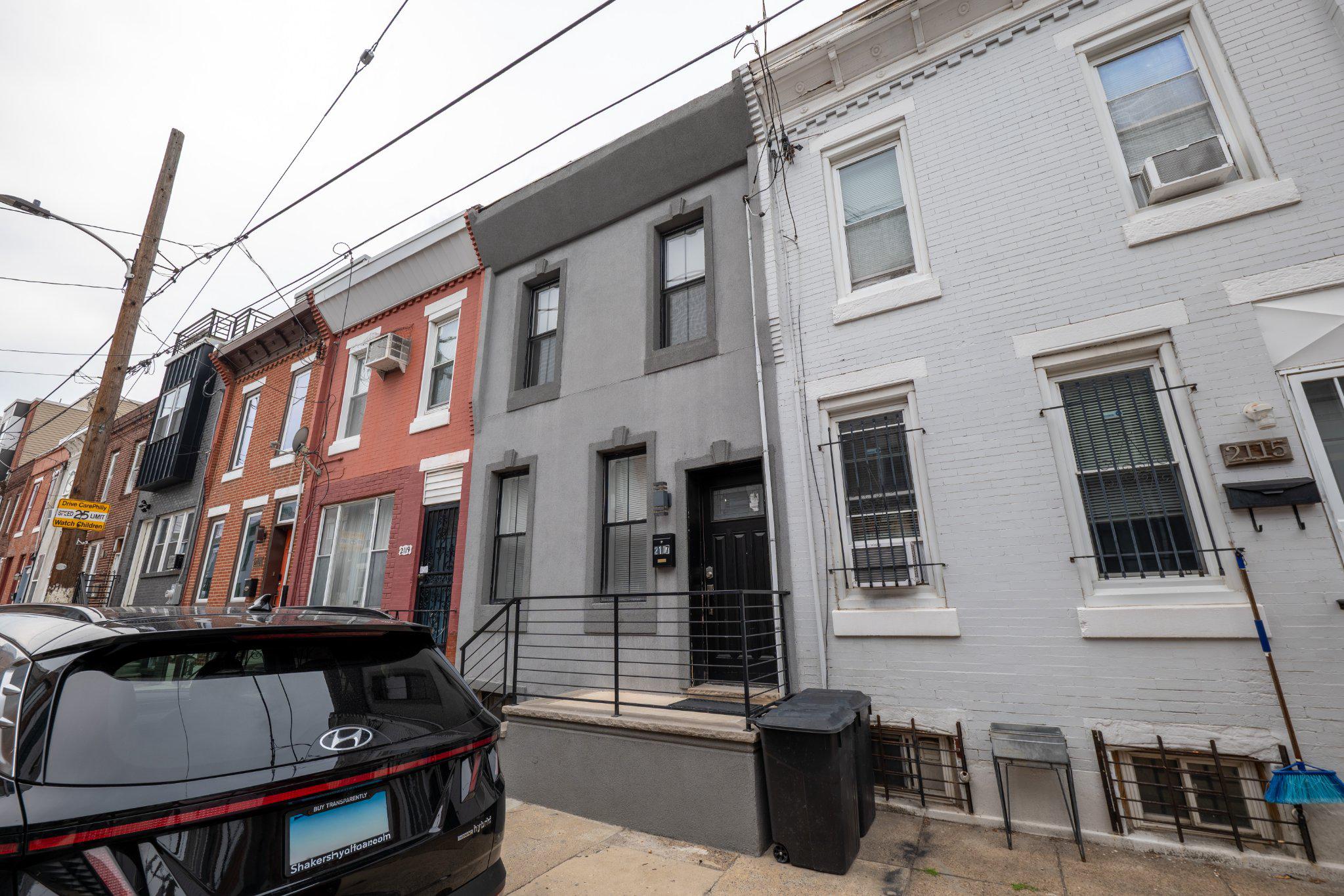 Fully renovated from top to bottom, 2117 Mountain St is a turnkey Point Breeze rowhome with the kind of update list that actually matters: new roof (2023), HVAC (2022–23), water heater (2023), refreshed exterior, and all-new kitchen, bath, and flooring throughout. The main level flows naturally from a sun-filled living room anchored by a tiled accent wall and electric fireplace into an open dining area and a well-appointed kitchen featuring quartz countertops, stainless steel appliances, and generous cabinet storage. Step out back to a private enclosed yard, a rare find on a quiet residential block. The partially finished basement with tiled floors and laundry adds flexibility for a home office, gym, or extra storage. Upstairs, two comfortable bedrooms share an oversized bath with a floating vanity and full tile surround. The location keeps you connected without the noise, walkable to restaurants, coffee, and neighborhood staples with quick access to SEPTA routes, area hospitals and universities, and both I-76 and I-95. Move-in ready. Schedule your showing.