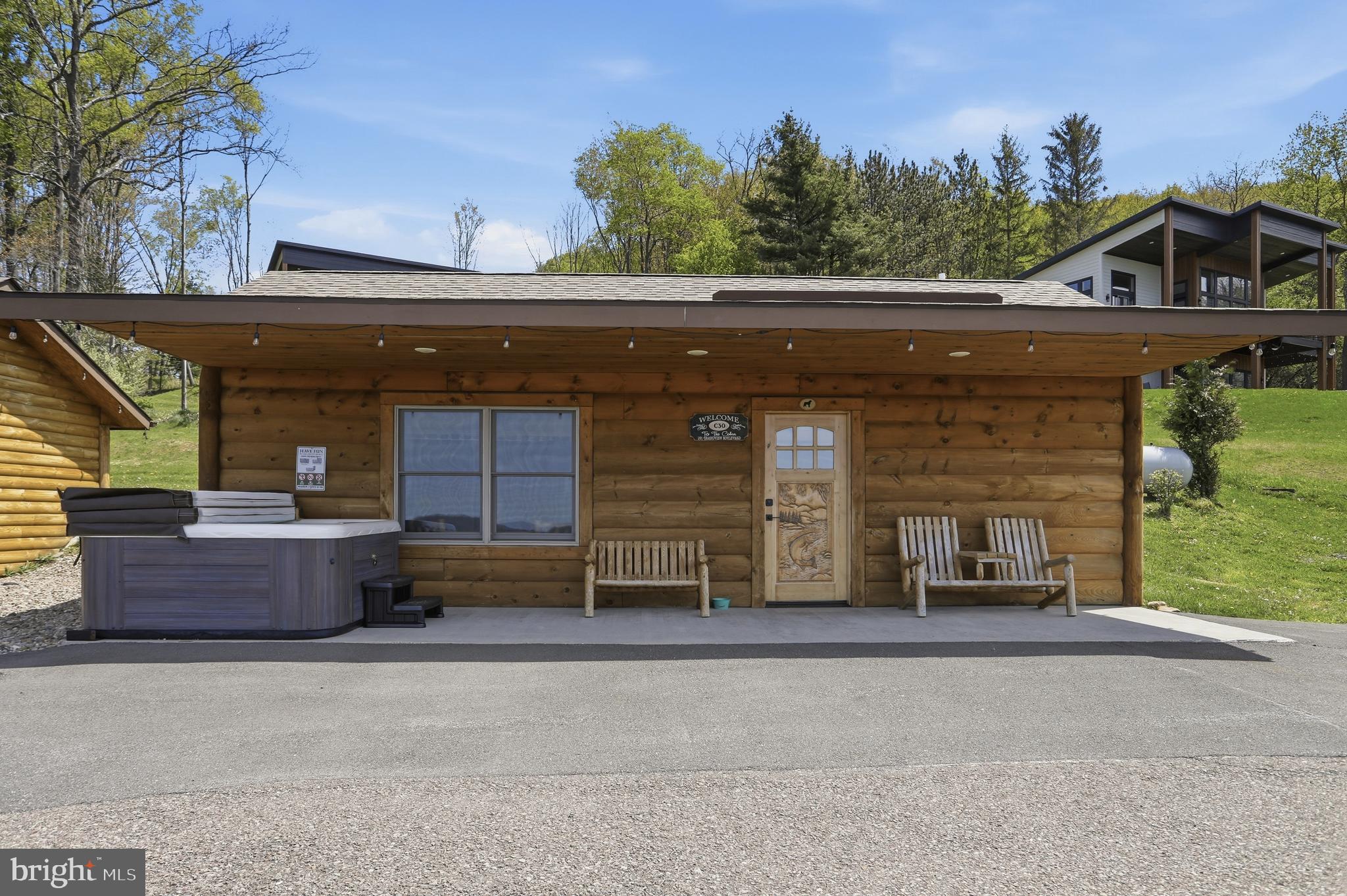 BOAT SLIPS! LAKE ACCESS & VIEWS! 4TH OF JULY FIREWORKS VIEWS! SKI SLOPE VIEWS!  Cabin #30 at The Lodges of Sunset Village is a detached efficiency unit with a king bed, a kitchenette, a full bath, and approximately 576 square feet, fully furnished and turnkey. This unit has a porch, hot tub and patio, too! It's situated on a lot with premier lake views!

Rich in mountain character and charm, this log cabin features uniquely carved wooden doors, beautiful beamed ceilings, warm wood walls, and inviting spaces that create an authentic lake-and-mountain retreat feel. Additional features include lake and ski slope views, expansive decks, upgraded finishes, open-concept living, a stacked-stone gas fireplace. Enjoy incredible views of Deep Creek Lake and Wisp, along with front row seats for seasonal beauty and memorable moments, including views of the annual July 4th fireworks. 

This property has a proven rental history, generating an average of  $38,031  in annual gross
rental income creating an exciting opportunity for
buyers seeking both personal enjoyment and investment potential. Experience one of Deep Creek Lake’s
newest ownership opportunities at The Lodges at Sunset Village. For the first time ever, fully furnished lake
area cabins are being offered for individual ownership in a breathtaking community featuring incredible lake
and Wisp ski slope views. Community amenities include lake access with 10 shared dock slips and an
impressive 1,320 square foot waterfront dock area perfect for fishing, swimming, launching kayaks,
relaxing by the water, and enjoying summer fun at the lake. Residents and guests also enjoy a lakeside
gazebo, playground, fire pit, gathering areas, pet-friendly accommodations, abundant parking, and on-site
professional management. The monthly condo fee provides exceptional convenience, including most
utilities, snow removal, trash service, and yard maintenance, for a low-maintenance ownership experience. Whether you're searching for a vacation retreat, income-producing investment, or both, The Lodges at
Sunset Village offers a rare opportunity to own at Deep Creek Lake. Stop by our on-site Sales Center at The Lodges Gatehouse (23900 Garrett Highway) during open hours to learn more, explore ownership opportunities, and get your questions answered: Thursdays 2:00–6:00 PM, Fridays 1:00–5:00 PM, Saturdays 10:00 AM–5:00 PM, and Sundays 10:00 AM–2:00 PM or call today for details and your private showing!