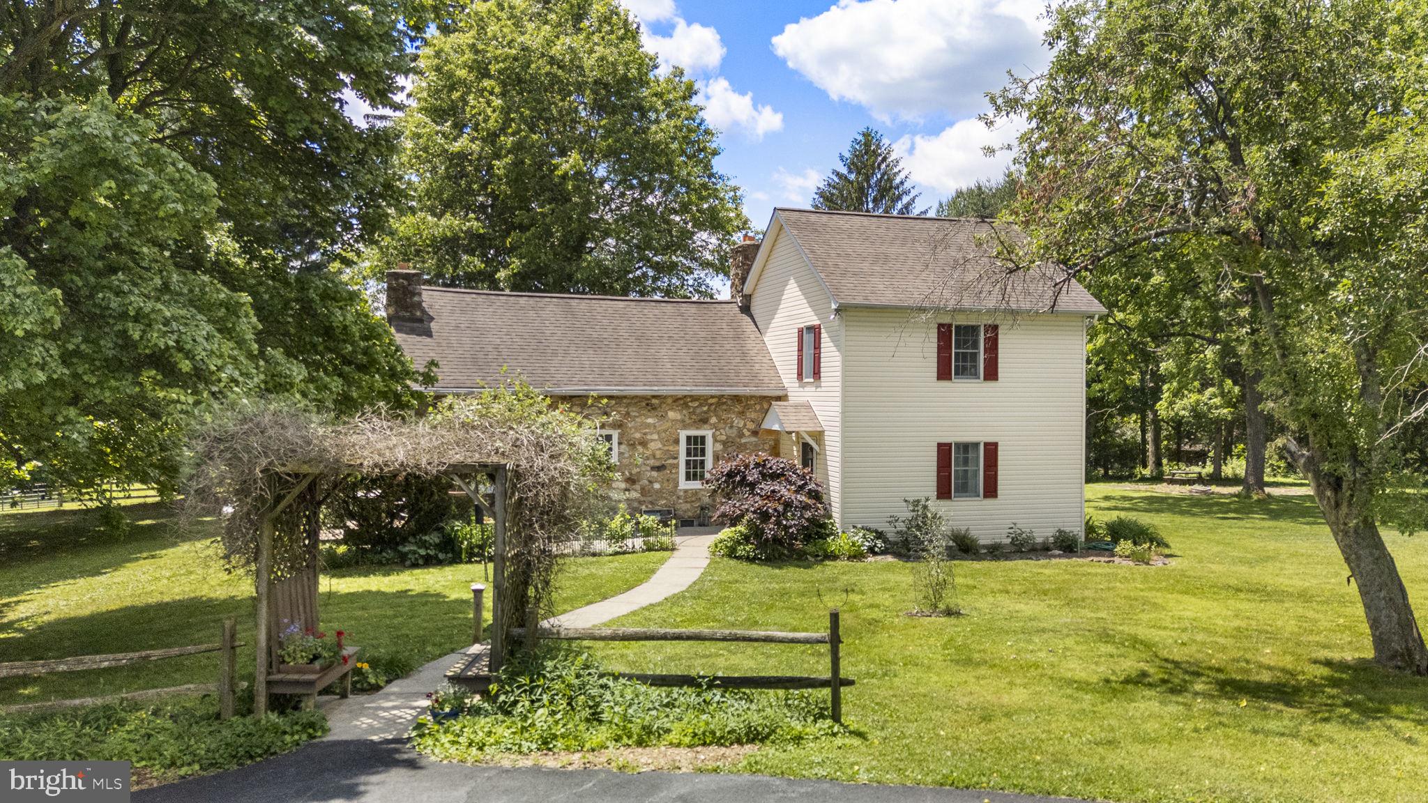 Welcome to 404 Indian Run Road, a hidden gem nestled on 7.11 picturesque acres in Glenmoore and located within the award-winning Downingtown Area School District. Offering the perfect blend of country charm, privacy, and equestrian amenities, this country home is ready for its next owner! Approach the home and be greeted by a welcoming front patio, the perfect place to relax with your morning coffee or unwind after a long day while taking in the peaceful surroundings. Step inside to a cozy family room, complete with a conveniently located powder room nearby. Continue through the main level to the inviting dining area, highlighted by a stunning stone fireplace that serves as the heart of the home. Just beyond, a screened porch provides the ideal setting to enjoy panoramic views of the property and backyard oasis throughout the seasons. The adjoining kitchen and breakfast nook offer a functional layout for everyday living and entertaining. Upstairs, you'll find a spacious bedroom to your left and a full hall bathroom nearby. Across the hall is your expansive primary suite, featuring a walk-in closet, private ensuite bathroom, and separate stairway access directly from the living room. Outdoor living shines at this property. Step from the screened porch onto the paver patio, an ideal space for summer barbecues, outdoor dining, and entertaining family and friends while overlooking the scenic landscape. Designed with horse enthusiasts in mind, the property is equipped with a large barn featuring multiple stables, fenced paddocks and pens, a storage shed, and abundant storage throughout the outbuildings. Whether you're housing horses, pursuing hobby farming, or simply seeking room to roam, this property offers endless possibilities! Buy with peace of mind knowing there is a propane fueled stand-by generator. Privately tucked away yet conveniently located near Marsh Creek State Park, major commuter routes, shopping, dining, and everyday conveniences, 404 Indian Run Road presents a rare opportunity to enjoy country living without sacrificing accessibility. Experience the beauty, tranquility, and versatility of this one-of-a-kind Glenmoore property!