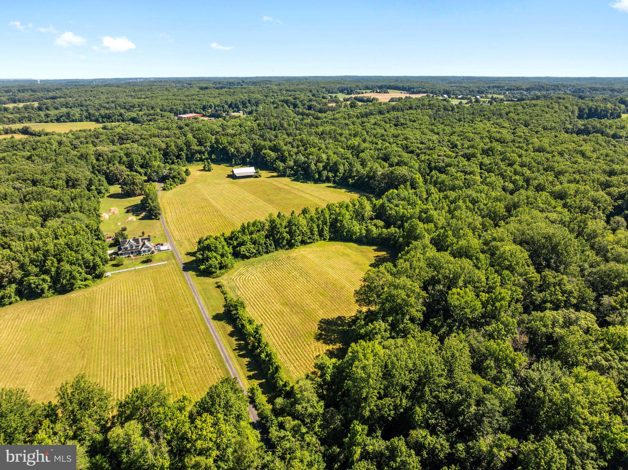 A once-in-a-generation opportunity to own over 23 picturesque acres in the heart of Davidsonville. Offered for the first time in over 40 years, this remarkable property consists of two separately deeded parcels totaling approximately 23.17 acres (21.31 acres and 1.86 acres combined), creating an exceptional opportunity for those seeking privacy, recreation, farming, equestrian pursuits, or the potential for future residential use. The 21.31 acre parcel is predominantly cleared, offering sweeping pastoral views framed by mature trees along the perimeter. The adjoining 1.86-acre parcel provides additional privacy and flexibility with possible residential potential. Existing improvements include a substantial barn that could easily be converted for horse stalls, a second large barn currently used for storage, and a former airplane hangar offering abundant storage or workshop space. A previous percolation test was completed for a proposed homesite on the 21.31-acre parcel. Based upon preliminary discussions with Anne Arundel County, there appears to be potential for at least one residential homesite, with the possibility of additional residential opportunities on the adjoining parcel subject to percolation, engineering, and all county approvals. Buyers are responsible for conducting their own due diligence and verifying all zoning, percolation, and development potential with Anne Arundel County.  Tucked away from the road and accessed by a charming private bridge spanning a peaceful stream, this property offers a sense of arrival that is increasingly hard to find. Whether you're dreaming of a private country estate, a multigenerational retreat, an equestrian property, continuing agricultural use, or simply preserving an extraordinary piece of Davidsonville countryside,  this is a setting that feels worlds away while remaining just minutes from everything.  A truly rare opportunity to own one of the area's most unique and private properties.