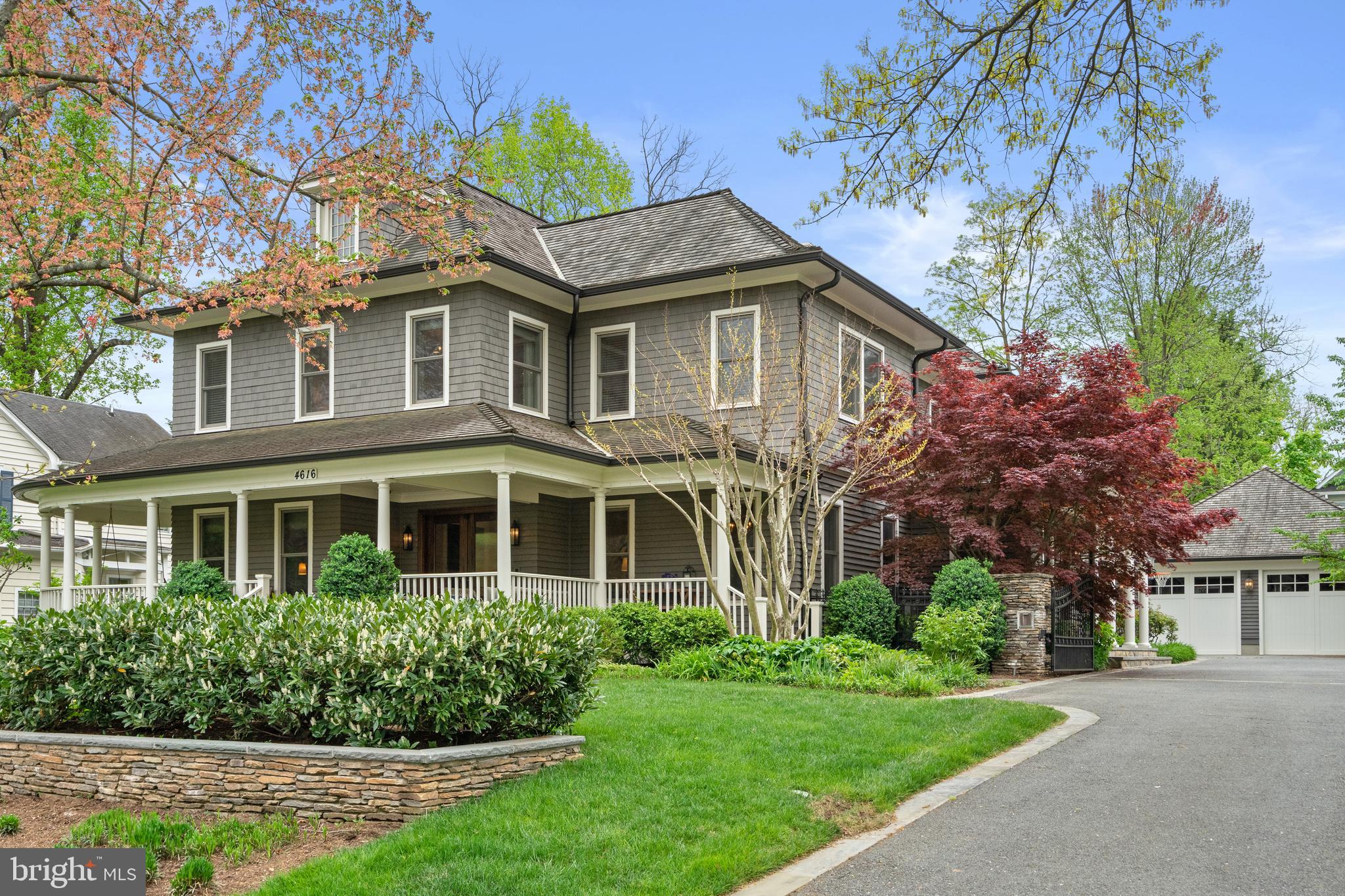 Located within the historic Village of Drummond neighborhood and sited on a flat .36-acre lot, this stunning residence boasts exceptional curb appeal, highlighted by its distinctive turret and an inviting wrap-around front porch. Constructed in 2010 by the renowned Jim Gibson and Sandy Spring Builders, this home spans over 8,000 square feet of meticulously designed and crafted interior living space, marrying timeless elegance with the luxuries of modern-day living. Upon entry, the home greets you with a gracious foyer complemented with inlay wood floors, thick crown moldings, paneled walls, and expansive sightline views through to the rear of the property. The main hall, featuring an oversized coat closet, guides you seamlessly into the generously scaled living areas, each designed with meticulous attention to detail. The home’s wood-accented office, complete with French doors, opens to a light-filled living room graced by three large windows. The adjacent dining room has a coffered ceiling and sits conveniently near the butler's pantry, which boasts marble countertops and ample storage, ensuring seamless entertaining. The heart of this home is its well-appointed kitchen, featuring a walk-in pantry, a marble center island with a breakfast bar, high-end appliances, including dual Miele refrigerators and freezers, and a deep farmhouse sink with a window overlooking the lovely rear yard. The kitchen adjoins a sunny breakfast are with exterior access and a spacious family room, anchored by a soaring ceiling and elegant fireplace. Additional main level highlights include a screened porch, mudroom, and powder room. Ascending to the second level, you are greeted by three luxurious bedroom suites, plus the luxurious primary. This sanctuary offers an exceptional walk-in dressing room, a private sitting room, a coffee bar with a mini-fridge, and a balcony with serene views of the rear grounds. The en-suite primary bathroom features dual vanities, a multi-feature shower, and a separate soaking tub. The additional bedroom suites are equally impressive, offering ample sunlight and large closets, alongside a convenient hall laundry room. The third floor presents additional living space with another generous bedroom, bathroom, and extensive storage. The lower level is a haven for entertainment and leisure, featuring a large playroom, temperature-controlled wine cellar, media room with a gas fireplace, gym, an additional bedroom, a full bathroom, and large storage room. Outside, the residence showcases beautifully landscaped gardens, multiple terraces, mature trees, a fire pit area, and an irrigation system, ensuring a picturesque setting for outdoor enjoyment. Security is paramount for this home, with wrought iron fencing and an automatic gate. Also, a detached two-car garage and additional driveway parking accommodate multiple vehicles. This remarkable residence is a testament to unparalleled craftsmanship and design, offering a blend of luxury, comfort, and sophistication in one of the most coveted neighborhoods in Montgomery County.  The location is walking distance to parks, trails, Metro, and restaurants and shopping in downtown Bethesda.