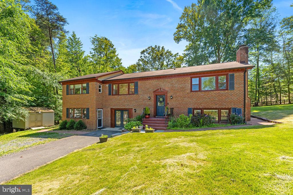 Nestled in the serene community of The Estates in Stafford, VA, this charming split foyer home offers a perfect blend of comfort, style, and multigenerational living. With 4 spacious bedrooms and 5 well-appointed bathrooms, this residence is designed for both relaxation and entertaining. The cozy family room, conveniently located off the kitchen and dining room. A large open primary bedroomwith a large soaking tub, separate shower and double vanity. The main level has 2 more bedrooms and 2 full baths. The fully finished basement, complete with an outside entrance, provides additional living space and endless possibilities for a home office, gym, or playroom. The basement features a bedroom, family room with wood burning fireplace with a brick mantel, full bath, and laundry room. The addition on the home has an apartment area with its own kitchenette, full bath, and bedroom with its own entrance. Step outside to discover extensive hardscaping that complements the lush, wooded views, offering a tranquil retreat right in your backyard. Enjoy the outdoors on the spacious deck, ideal for summer barbecues or quiet mornings with a cup of coffee. This home is equipped with modern appliances, including a dishwasher, microwave, and washer/dryer, ensuring convenience in your daily routine. With a paved driveway and 2 sheds, practicality meets elegance in this well-maintained property. Set on a generous 1-acre lot, this home is a true sanctuary, surrounded by nature yet close to all the amenities you need. Experience the warmth and charm of this delightful residence, where every detail has been thoughtfully considered for your comfort and enjoyment. The septic has a 4 bedroom perc.