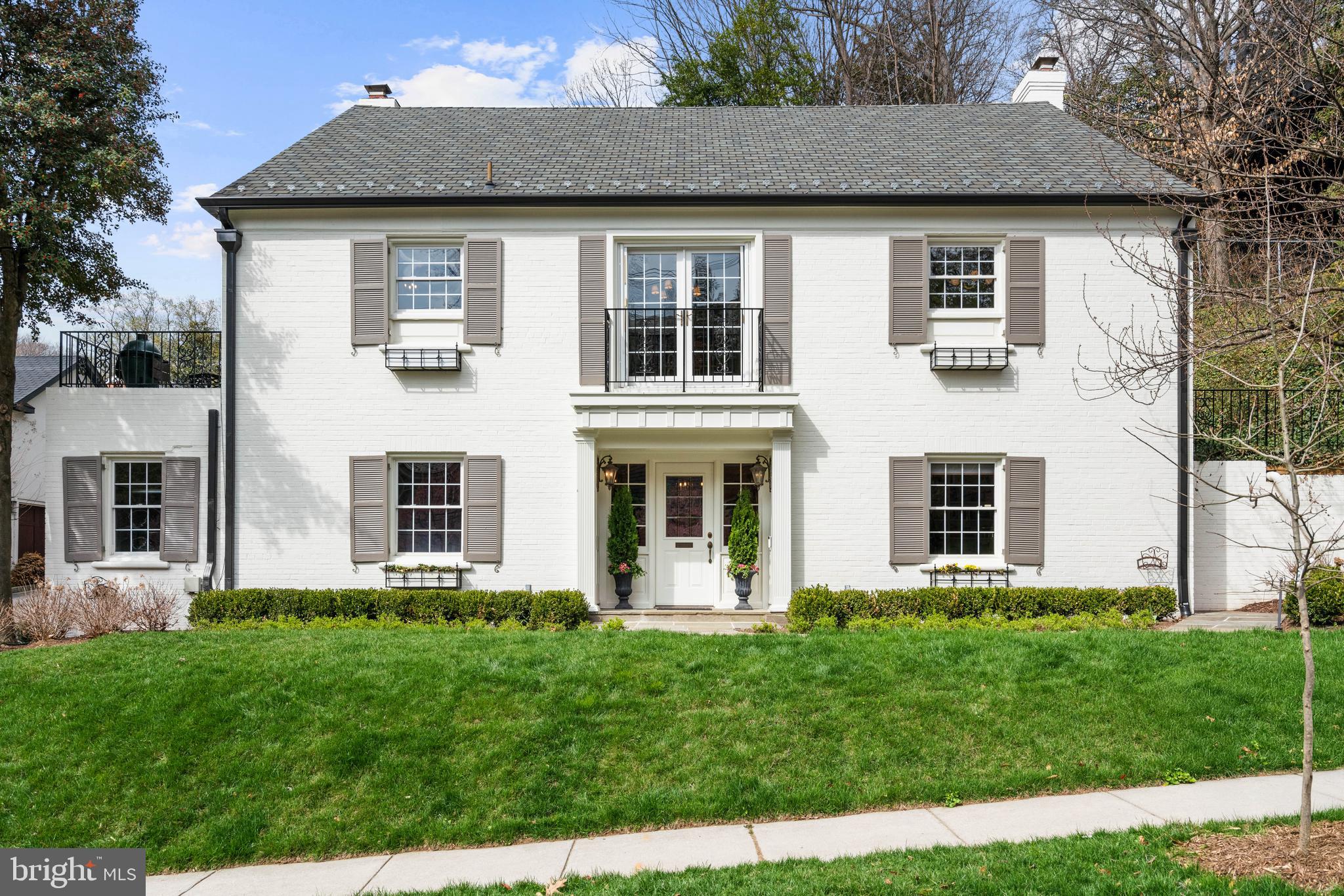 Exuding timeless elegance on one of Massachusetts Avenue Heights’ most coveted tree-lined streets, 2618 30th Street NW is a distinguished residence that effortlessly blends luxury and comfort. A gracious stone walkway leads to a covered portico, welcoming you into a generous foyer revealing refined moldings and meticulously crafted architectural details set throughout the home. 
The entry level is thoughtfully designed for both flexibility and privacy, featuring a richly appointed study with floor-to-ceiling built-in bookshelves and intricately carved cabinetry, which can easily serve as an additional bedroom with an adjacent full bathroom. A spacious secondary bedroom suite on this level is anchored by a marble-surround fireplace and complemented by a beautifully appointed kitchenette with marble countertops and a custom tile backsplash. Beyond, a sophisticated mudroom showcases classic black-and-white tiled flooring, bespoke sage-toned cabinetry with integrated storage, a utility sink, and a full laundry area. The two-car garage is accessed from this level.  
The main level unfolds with an inviting living room centered around a fireplace and framed by expansive windows, filling the space with natural light and offering seamless access to the rear grounds. The chef’s kitchen, appointed with stainless steel appliances, custom cabinetry, and marble countertops, opens directly to a terrace, presenting a distinguished space for seamless indoor-outdoor living. A formal dining room, illuminated by French doors overlooking the verdant streetscape, provides an elegant setting for entertaining. The primary suite is a serene retreat, featuring generous closets and a marble-clad bathroom with a dual vanity, frameless glass shower, and refined brass fixtures. An additional bedroom and full hall bathroom complete the main level.
Upstairs, two generously sized bedrooms, each including a walk-in closet, share an elegantly appointed full bathroom. Seamlessly extending from the interior, the fully fenced rear garden and yard are framed by mature trees and lush greenery, featuring a staircase to the attached two-car garage.
Ideally located just moments from The National Cathedral, sought-after independent and public schools, and Rock Creek Park, this exceptional home offers an ideal balance of privacy and accessibility. Surrounded by nature yet convenient to downtown, it is within easy reach of parks, trails, and the vibrant destinations of Georgetown, Dupont Circle, and the shops and restaurants of Cathedral Commons and City Ridge.