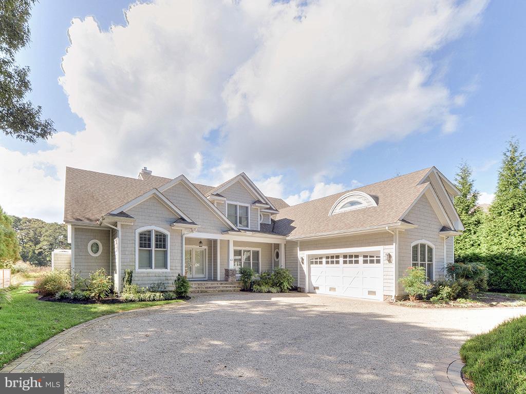 Welcome to 63 Anchor Road, an exhibit of coastal splendor in the sought-after North Shores community. This canal front home offers breathtaking views of the Lewes and Rehoboth Canal and its neighboring wetlands. This property's coastal design with a cedar shake exterior, circular gravel drive and impeccable landscaping offer an elegant, yet charming elevation. Upon entry, panoramic views of Mother Nature offer a serene backdrop and the open floor plan provides excellent flow. The beautiful great room is finished with floor to ceiling windows, custom moldings, pine floors and accented with a gas fireplace and custom built-in surround. The spacious dining area is a superb setting for entertaining and leads into the gourmet kitchen complete with a large island, granite and wood counters, stainless steel appliances and an adjoining butler's pantry offering a wet bar, wine fridge, extra cabinet space and refrigeration. Unwind in the grand first floor master bedroom featuring a large walk-in closet with custom built-ins, private deck overlooking the canal, spa like bath complete with heated marble floors, large tile shower and soaking tub. In addition, the first level boasts a cozy den, spacious laundry/mud room and powder room. Walk upstairs to find an additional 5 bedrooms, 4 full baths and a large living area. 63 Anchor s outdoor livings spaces are equally as impressive complete with a light filled screened porch and multiple sun decks situated adjacent to the common areas. The screened porch offers tiled floors, ceiling fans and vinyl tech windows allowing you to enjoy the space through various seasons. The property boasts multiple outside showers, a bulkhead for a boat, spacious irrigated yard and great privacy. With additional features such as a 2-car garage, plantation shutters, geothermal HVAC, tankless hot water heater and an amenity rich coastal community, this property leaves little to be desired and is truly a must see!