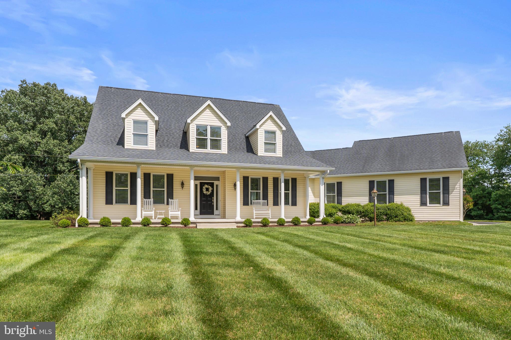 Picture-perfect on four pristine acres in sought-after West River, this exceptional Country Cape Cod offers over 5,200 square feet of meticulously maintained living space in a peaceful park-like setting. Built just 11 years ago, this home combines timeless design with modern comfort while remaining conveniently located to Annapolis, Washington, and Baltimore.
From the moment you arrive, the inviting front porch, manicured grounds, and expansive lawn showcase the care and attention. Inside, gleaming hardwood floors flow throughout the main and upper levels. The welcoming foyer opens to a formal dining room and private office, while the heart of the home features a stunning white gourmet kitchen with an oversized center island, expansive granite countertops, double wall ovens, warming drawer, abundant cabinetry, and generous table space overlooking the patio and rose gardens.
The open-concept family room is anchored by a gas fireplace and large windows that capture serene views of the surrounding landscape. The spacious main-level primary suite offers a luxurious retreat with an oversized walk-in closet, soaking tub, glass-enclosed shower, dual vanities, and private water closet.
Upstairs, a loft provides the perfect space for a study area, playroom, or reading nook. Two generously sized bedrooms share a bath with dual sinks and abundant storage. Throughout the home, thoughtfully designed closets and storage spaces provide exceptional functionality.
The finished lower level expands the living space with a massive recreation room, a fourth bedroom, a full bath, and a walk-up exit to the backyard. High-quality ceramic tile flooring with a wood-look finish adds warmth and durability. Hobbyists and craftsmen will appreciate the dedicated workshop, complete with a built-in workbench and electrical service designed for tools and equipment.
Outdoor living is equally impressive. The brick paver patio creates the perfect setting for entertaining, surrounded by beautiful rose gardens and professionally maintained landscaping. Underground irrigation keeps the grounds lush, while a detailed planting map identifies the extensive collection of trees, shrubs, and perennials. A centrally located shed with electricity and ramp access provides convenient storage for tractors, lawn equipment, and gardening supplies.
Additional highlights include a three-car garage, parking for more than twelve vehicles, and an idyllic setting that offers privacy, room to roam, and endless opportunities to enjoy nature.