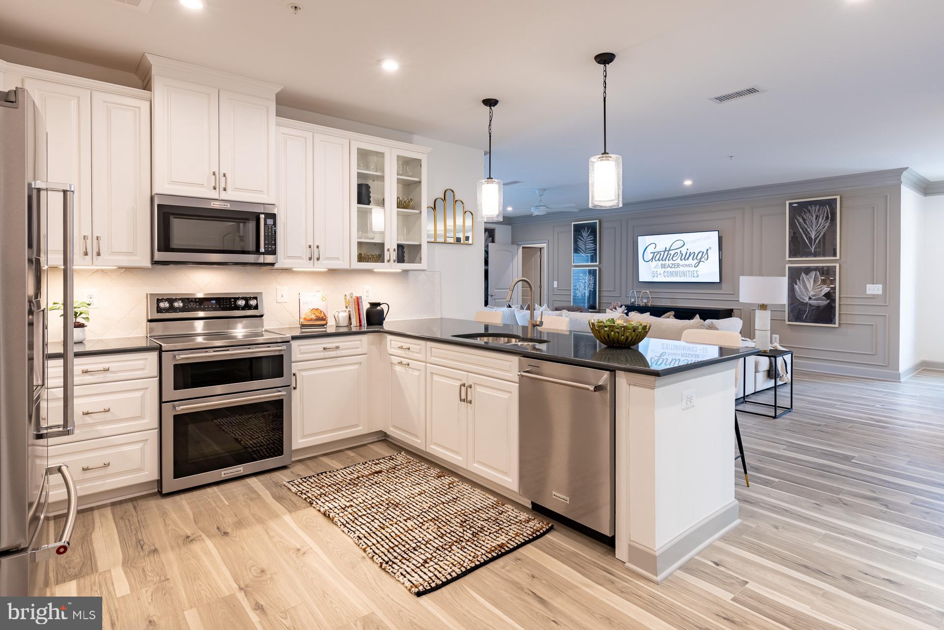 Ready for Fall move in!! Welcome to the Wiltshire, a beautifully designed single-story condo home in Gatherings at Cabin Branch, Clarksburg’s vibrant 55+ community by Beazer Homes. This spacious new construction offers 3 bedrooms, 2 baths, and an impressive 2,031 sq. ft. of thoughtfully crafted living space. As you enter, a spacious foyer welcomes you—perfect for dropping your bags or shoes and transitioning into the comfort of home. The open-concept layout invites natural light and effortless flow throughout. The modern kitchen features an oversized island, abundant cabinetry, and a walk-in pantry, and it overlooks the expansive living area, creating a seamless space for connection and relaxation. A flexible adjacent space offers room for formal dining or a private den, tailored to your lifestyle. Retreat to your primary suite, complete with a spa-inspired en-suite bath featuring a dual vanity, soaking tub, walk-in shower, and a generous walk-in closet. Two additional bedrooms provide versatility for guests, hobbies, or a home office. Enjoy peaceful mornings or relaxing evenings on your private balcony and take advantage of the walk-in laundry room for everyday ease. Located in a controlled-access building, residents enjoy exclusive amenities like a billiards room, movie theatre, golf simulator, and more. Additional highlights include a 1-car garage and valet trash service three times a week. Plus, enjoy access to the clubhouse, fitness room, community gardens, and nearby Clarksburg Premium Outlets for shopping and dining. Don’t miss your chance to live the lifestyle you’ve earned. Special buyer incentives may include closing cost assistance—schedule your appointment today and make the Wiltshire your new home.