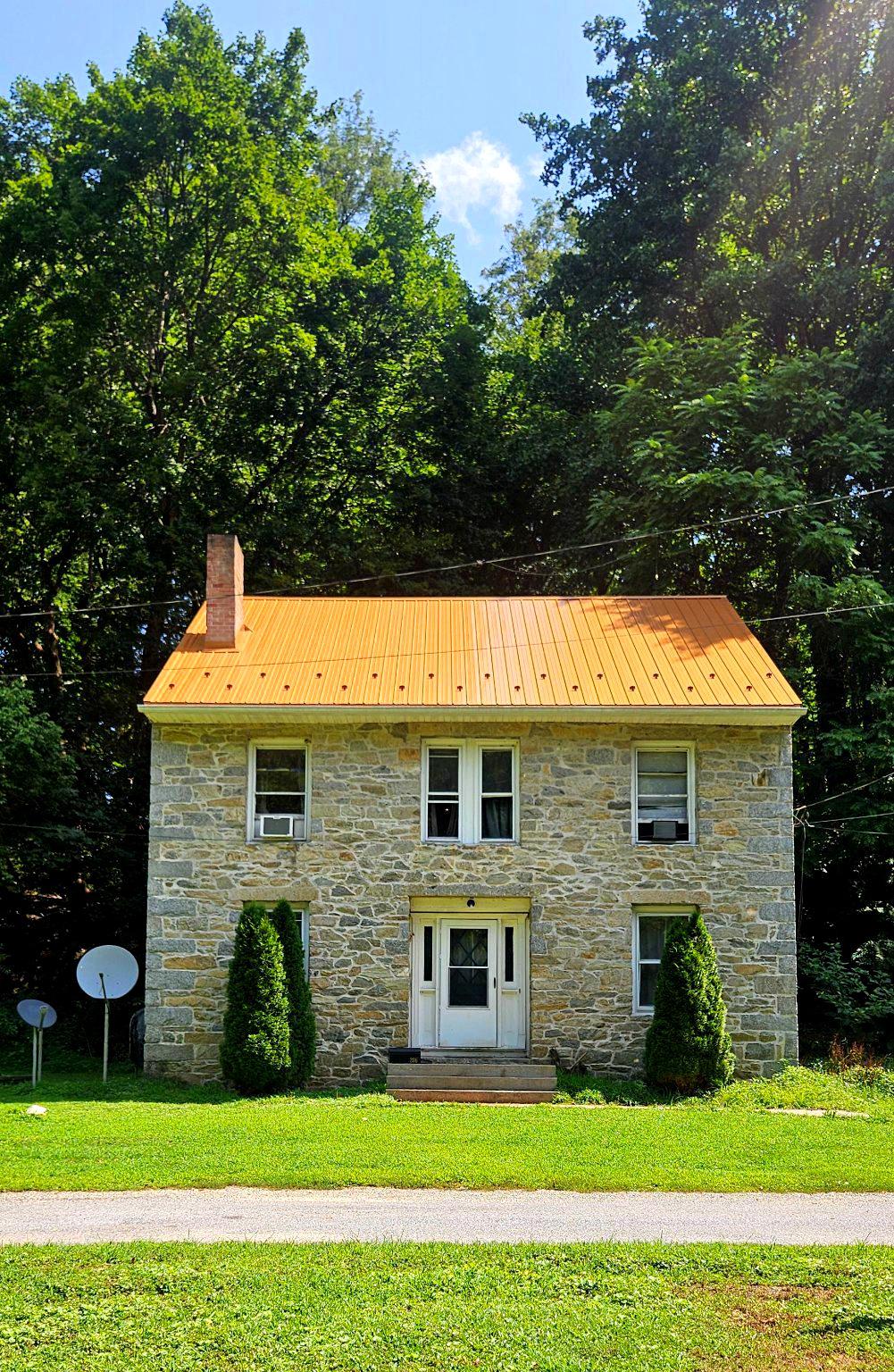 Welcome to 206 Octoraro Rd in Conowingo. This 1890's home is rich in history and a hidden gem made from local fieldstone and stucco. A true "Rarely Available" opportunity to own a home that has remained in the same family for over 50 years. The current owner hopes to hand it over to like minded individuals ready to start their legacy and make memories for generations to come. Nestled along the banks of the Octoraro Creek, early history claims the Indians coined the name Octoraro which means "rushing waters". This waterpower provided energy to the variety of grist, paper, lumber, saw and iron mills up and down the creek that employed hundreds in bygone eras. The iron mills helped build and develop several railways including extensions of the Pennsylvania Railroad we now know as Amtrak lines. The brand new eye catching copper colored metal roof is a stunning update that adds interest and charm in addition to being a lasting improvement. Entering the front door you are welcomed to 2400 Sq Ft of living space designed with an open living area featuring a brick wood burning fireplace. You can access the separate dining area from both the living room and the kitchen. The kitchens rustic charm features pine cabinets, a moveable island and a shelving unit with microwave. All appliances convey. New dishwasher is included but not installed. A large kitchen closet has hook up for washer and dryer or use as pantry. Side kitchen door leads out to small patio. Main level half bath has rustic elements and adds a touch of modern with colorful glass vessel sink. Hardwood flooring throughout home with the exception of vinyl plank in the kitchen and ceramic tile in bathrooms. Proceed to the upper level which is home to 4 light filled bedrooms each with ample closet space. A full bath with large linen closet is centrally located to all bedrooms.The home's straightforward layout is characteristic of late 19th-century architecture, designed with practicality and everyday family living in mind while retaining its historic character. This property is full of potential and ready for your personal touch. It could benefit from cosmetic updates. Being sold As-Is. Property septic system is in need of repair/replacement. Price reflects this. Please understand this condition may make certain financing challenging. The generous lot extends across the road giving you the flexibility to incorporate outdoor living spaces, lush gardens, or even a cozy fire pit for those starry nights. Chickens and goats were once raised on property and old goat house still remains. No HOA. Whatever you decide you have endless potential to create a space that reflects your personal style and vision. The location is ideal, offering a peaceful atmosphere while still being conveniently close to local amenities. The right buyer will see the value of this property and revel at the opportunity to make it their home. Being located on a No Outlet road affords peace and privacy while being maintained and plowed by Cecil County. The long and narrow road approach feels like a private driveway then reveals the enclave of just three homes. The area is prime for nature lovers, bird watchers, hunters, hikers and fishermen. Nearby Havre de Grace and Port Deposit have wonderful dining, shopping and boating amenities. The Conowingo Swimming pool is a local public outdoor facility and a great place to cool off. Golfers will appreciate the public course at Chesapeake Bay Golf Club in Rising Sun. This property is not just a piece of land, it's an opportunity to create a haven that you and your loved ones will cherish for years to come.  Don't miss out on this chance to turn your vision into reality. It's a special opportunity to embrace and craft an environment that is uniquely yours, in a location that offers both tranquility and convenience. Some photos and comments have been AI enhanced.