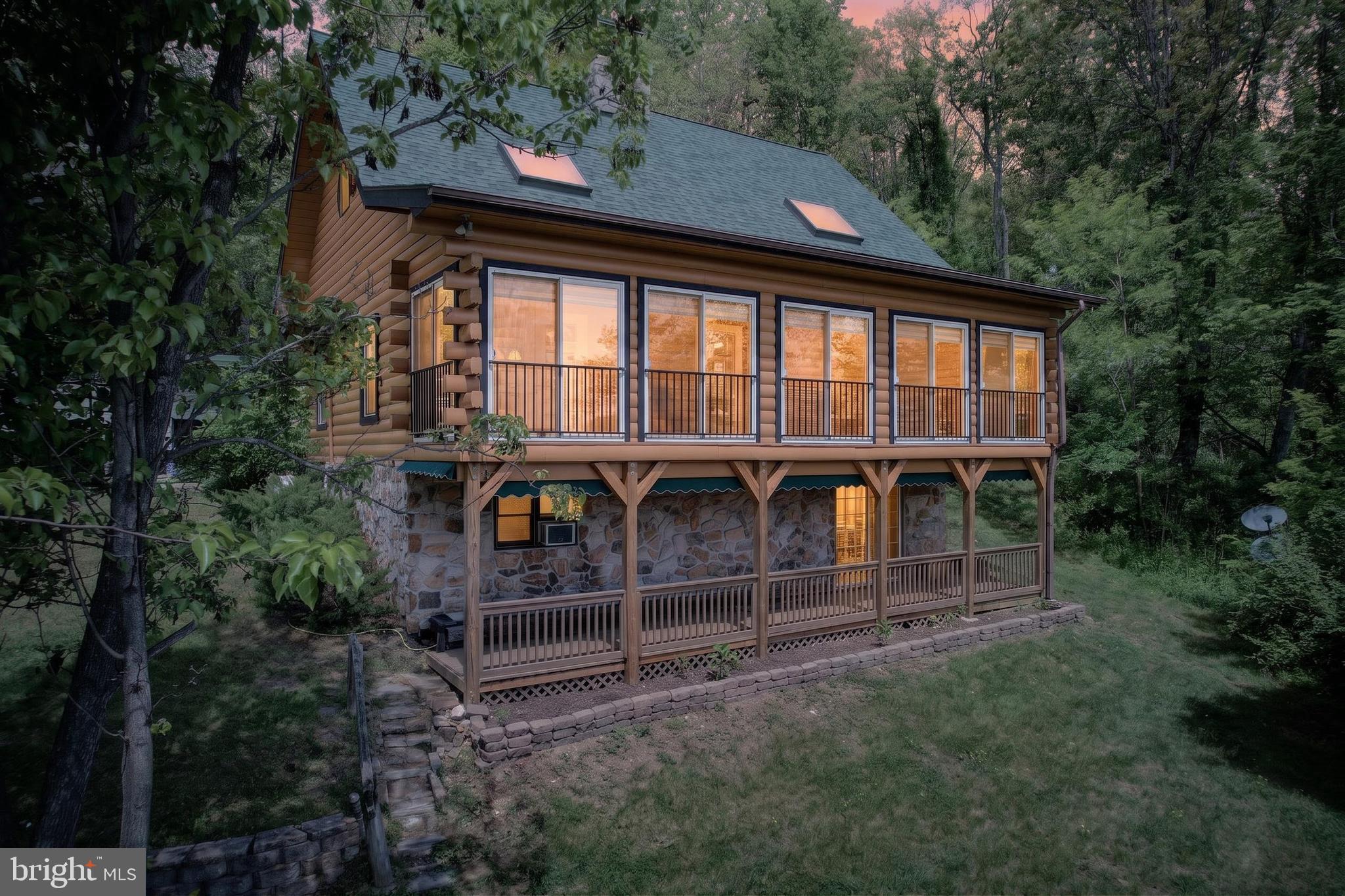 CASA DE PAZ - The personal residence and sales model for an original Lincoln Log franchisee, this home was built to the highest standards available. Sited on an elevated eight acres with views of the Piedmont countryside, it was designed to comfortably accommodate multi-generational requirements as well as being easily transformed into an attractive income producing asset through several distinct configurations as a rental. A massive two story stone fireplace anchors the open floor plan main level which includes the great room, kitchen, full length glass enclosed three seasons porch, two bedrooms (one with private sitting room) and one and a half baths. The upper level contains the master suite with sky lights, full bath with soaking tub and a large balcony seating area overlooking the great room. The walk-out basement/in-law suite can be entered via an interior stairway or from the covered front porch entrance and includes a living room, kitchen, two bedrooms and full bath for a total of over 3,200 square feet of finished space. Constructed with solid eight inch "D-cut" logs, the dwelling maintains a natural insulation factor for maintaining utility costs far below average. Recent updates include installation in 2026 of a five zone mini-split heating and cooling system, new roof, exterior painting and sealing in 2025 and a replaced well pump in 2023. Outdoor enthusiasts will enjoy nearby attractions including the 4,000 acre Thompson Wildlife Management Area, Appalachian Trail, Sky Meadows State Park, Shenandoah National Park, the Shenandoah River and numerous Virginia Designated Scenic Byways. The property is easily accessed by a paved driveway and is approx. 2.75 miles from the I-66 Markham exit on State maintained hard surfaced Belle Meade Rd.