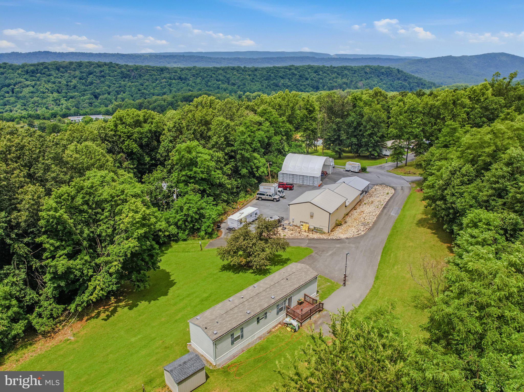 Calling all entrepreneurs, dreamers, and lovers of slow-smoked perfection—this turnkey commercial property is practically begging you to flip the "Open" sign. Sitting just steps from Berkeley Springs State Park, the location delivers steady foot traffic and a built-in audience hungry for something delicious.
At the heart of this rare offering is a versatile garage and shop, complete with a connecting one-bedroom apartment featuring a mini split system and full bath—instant rental income while you build your empire. Adjacent sits a fully equipped commercial Prepping kitchen, equipment included, ready for your culinary ambitions from day one.
The investment opportunities keep stacking up. A 2018 Clayton mobile home with two bedrooms and two bathrooms generates additional rental revenue, while two 40 ft shipping containers separated into 4 units each are  tucked beneath a carport providing secure storage. The 8 divided spaces are ready to rented out. 
Now for the showstopper: an entire roadside business ready to roll. The "Bob's Big Beef" operation includes a Southern Pride 700 smoker on trailer, a health-department-approved barbecue trailer, pig cookers, a funnel cake trailer, and a fry-and-veggie trailer. There's even a 2004 box truck outfitted with a commercial walk-in freezer and a 2004 GMC catering truck with warmers in the back, a Prepping kitchen with restroom, a covered pavilion for events, and—because every fair needs flair—a mechanical pony ride.
Generous lot size, ample parking, and a welcoming neighborhood round out this remarkable package. Whether you crave a full-time venture or a profitable side hustle, the recipe for success is already simmering here.
Bring your appetite and your vision—schedule your private tour today.