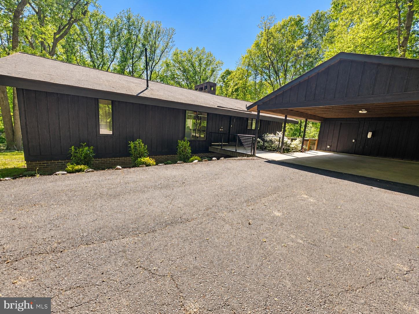 Set on 2 private acres in Vienna's Seneca Falls neighborhood, this architecturally designed 4-bedroom, 2.5-bath home is unlike anything else on the market — and it's been significantly upgraded since you last saw it. A detached multi-vehicle carport — wired with a Tesla charger — wraparound deck, natural stone patio, and a canopy of mature trees frame an outdoor experience that's hard to replicate at any price point.

Inside, the open great room commands attention immediately: soaring vaulted ceilings, a two-sided floor-to-ceiling stone fireplace, and an expanse of sliding glass doors that dissolve the line between inside and out. The dining room flows into a fully renovated gourmet kitchen with quartz countertops, glass-front cabinetry, commercial-grade appliances, an induction cooktop with built-in spigot, dual swan's neck faucets, beverage chiller, and a center island built for both cooking and conversation.

The primary suite is a genuine retreat — vaulted ceiling, tiered sitting area, private deck access, a brand-new walk-in closet, and a fully renovated en suite bath with dual vanities and luxury finishes. The walkout lower level adds a second fireplace, built-in wet bar, two additional bedrooms, a bonus room, and full bath.
New HVAC (July 2025), new water heater (2024), and a new alternative septic system (2024) with completed annual inspection. Hardwood, tile, luxury vinyl, and carpeted bedrooms throughout. Smart appliances, Nest thermostat, and move-in ready condition.

Minutes to Tysons, the Silver Line Metro, W&OD Trail, and Wolf Trap. A loft in the trees!