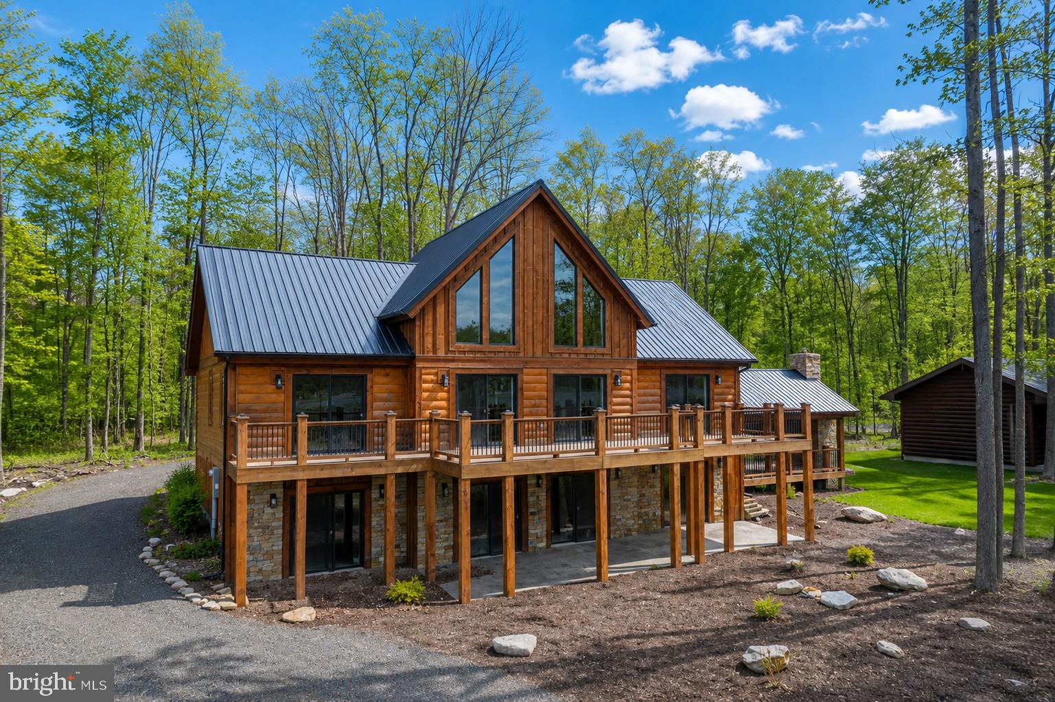 Panoramic Lake views in the Bray Run community, just minutes from Deep Creek Lake, state parks, and more! Built in 2025, this 4-bedroom, 4 full bath, 2 half bath log style chalet sits on 0.59 acres of peaceful, quiet serenity. Cathedral and beamed ceilings rise above an open layout filled with abundant natural light. Two stacked-stone fireplaces anchor the main living area and the lower-level family room. Granite counters, stainless appliances, and a custom island define the kitchen. A loft overlooks the main level, adding flexible living space. Outside, a deck and stamped-concrete patio lead to a covered pavilion with a wood-burning fireplace for year-round use. Central A/C, forced air heat, well water, public sewer, and a metal roof complete the package. If you’re looking for a new home that’s just off the beaten path, yet still offers easy access to everything Deep Creek Lake has to offer—this one needs to be on the list… Call today for details!