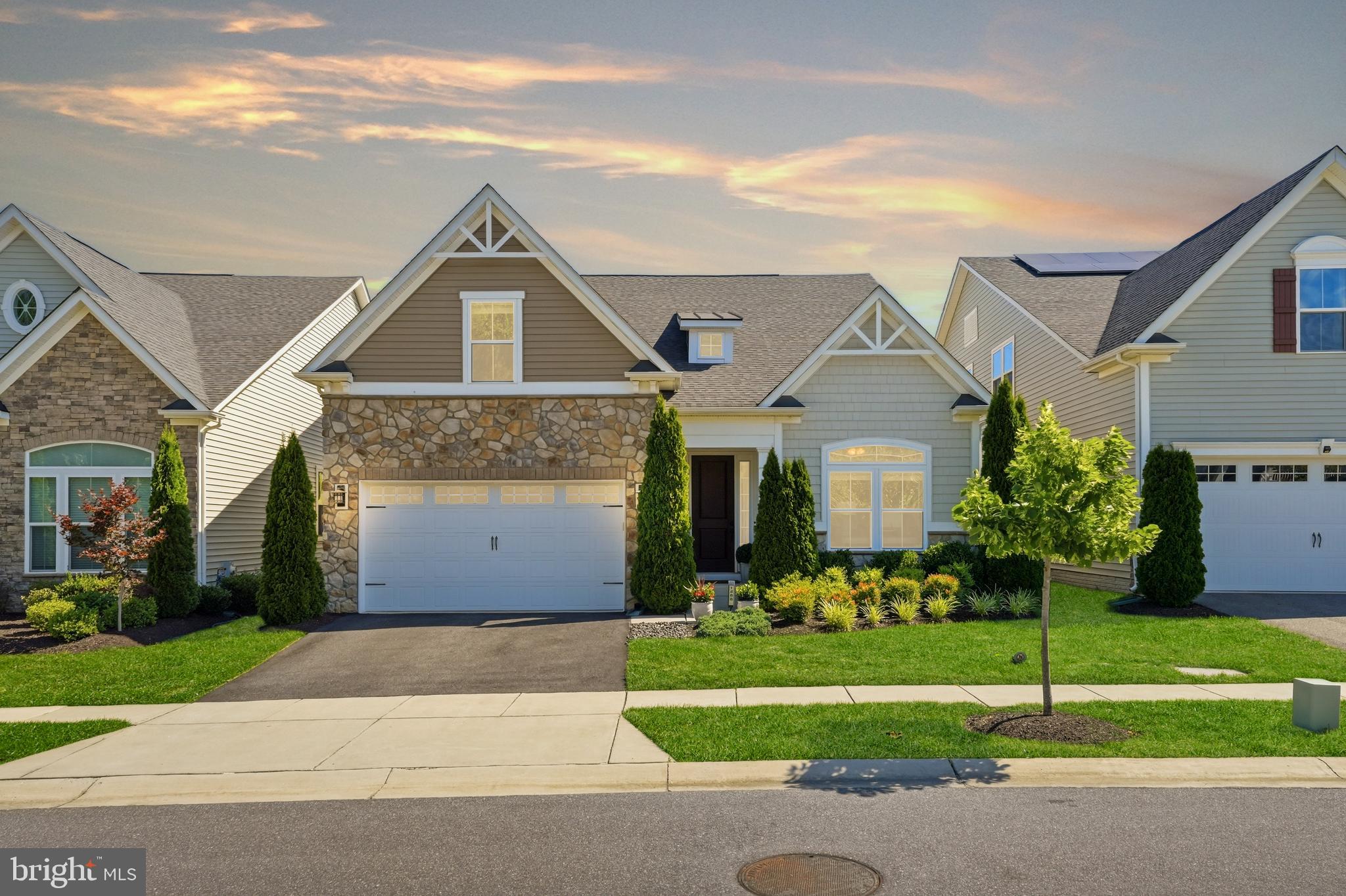 Welcome to 1488 Catbriar Way — a beautifully maintained 4-bedroom, 3 bath single-family home in The Regency at Two Rivers, one of Odenton's most sought-after 55+ active adult communities. Built in 2019 and thoughtfully updated by the current owners, this home is more spacious, more flexible, and more refined than anything else available in this community right now.

The main level immediately impresses with soaring 10-foot ceilings, hardwood floors throughout, and tray ceilings in the primary bedroom, primary bath, and great room. The great room is anchored by a gas fireplace with a stone surround and custom built-ins on either side — a warm, elegant centerpiece that the room is genuinely designed around. The kitchen delivers on every level — espresso cabinetry, granite countertops, and a massive center island, all elevated by brand new GE Café appliances (2023). Three legal bedrooms on the main level offer a rare degree of flexibility. The primary suite is exceptional — a true retreat with a connected sitting room large enough for a sofa and television, a transom window that fills the space with natural light, a tray ceiling, and an en-suite bath with double vanity, soaking tub, and separate shower. A second legal bedroom at the front of the home features a closet and is served by a full bath shared with the third main-level bedroom — ideal for guests or a private home office. Ceiling fans in every bedroom add comfort throughout. 

The spacious laundry room features a utility sink, room for a folding table, and connects directly to a mudroom with a storage cubby and bench — one of those thoughtful details that makes daily life genuinely easier. Two coat closets — one at the front entry, one adjacent to the laundry room — add storage that main-level living often lacks. The oversized two-car garage comfortably fits a mid-size truck and a full-size SUV simultaneously — with additional room for trash can storage and everyday essentials. A Nest thermostat and tankless water heater round out a main level designed to live beautifully on one floor.

Upstairs, a loft landing with seating area creates a comfortable transition to the upper level, which features one legal bedroom with an en-suite bath and a closet, plus a flex room with a window — perfect as a game room, studio, or private office. Nine-foot ceilings throughout.

The walk-up lower level is unfinished with 9-foot ceilings, rough-in plumbing already in place, and a new sump pump — fully prepped for a future recreation room, home theater, wet bar, or additional living space. The potential here is significant and the groundwork has already been laid.

Out back, a deck was added with a Sunsetter retractable awning — equipped with a wind sensor that automatically retracts in high winds — creates a comfortable, low-maintenance outdoor retreat usable in any season. Fresh neutral paint throughout gives the home a crisp, move-in ready presentation.

And then there is the community. Tucked in a quiet wooded enclave with no cut-through streets, The Regency at Two Rivers delivers resort-style living that is genuinely hard to replicate. The 15,000 square foot clubhouse features indoor and outdoor pools, a fitness center, tennis and pickleball courts, volleyball, basketball, a demonstration kitchen, and more — all exclusive to residents. Outside, enjoy parks, a pond, trails, a dog park, a community garden, and a barbecue area. The HOA covers weekly lawn maintenance, front mulch, and snow removal. 

Conveniently located with easy access to Annapolis, Baltimore, Washington DC, and Fort Meade, this is the kind of community and home that people spend years waiting for.