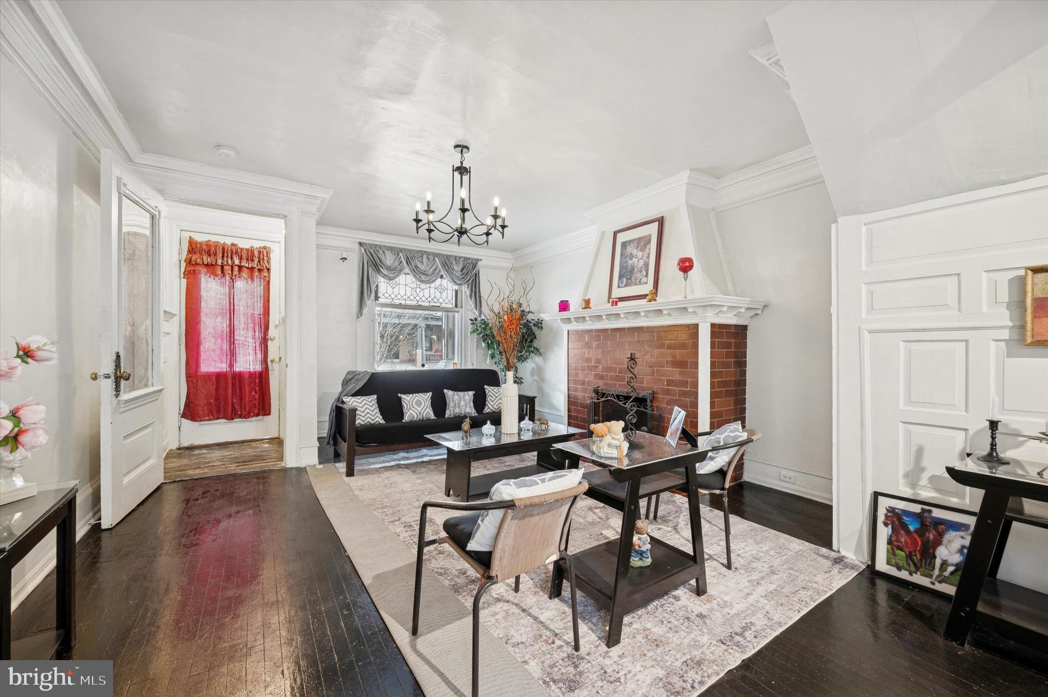 Welcome home to your sunlight filled multi level townhome that blends early twentieth century character with thoughtful updates. The main level welcomes you with  a vestibule entrance that leads to a cozy living room complete with fireplace, old world moldings and trim and an oversized window.  The dining area leads you to an efficient and modernized kitchen,  perfect for everyday cooking and complete with a gas range, microwave, granite countertops and refrigerator.  From here, there is an exit door to your fully fenced in backyard. Upstairs the second level hosts a full bathroom with a shower stall plus the primary bedroom and two additional bedrooms ideal for family or flexible use. The primary bedroom boasts your second fireplace.  The third level offers a second full bathroom with a shower stall and three more bedrooms that can accommodate guests, an office, or creative space. An unfinished attic provides storage or future expansion potential. The finished basement adds significant usable living space with a full bathroom with tub, generous storage, and a bonus room that works well as a rec room, home gym, or media room. This home sits in a vibrant neighborhood known for its abundance of classic row homes and a strong sense of community. The area offers convenient access to local shops, dining options, parks, and public transit making it easy to enjoy city living while still finding quiet residential pockets. Built with period details common to early twentieth century construction, this property presents a rare opportunity for buyers and investors seeking a spacious layout across multiple floors plus the flexibility of a finished basement. Public records and recent market listings indicate similar homes in the block have been updated and offered strong interest from buyers looking for space and value in the neighborhood. Both fireplaces are assumed to be working, however the seller has never used them.  Schedule your showing today!