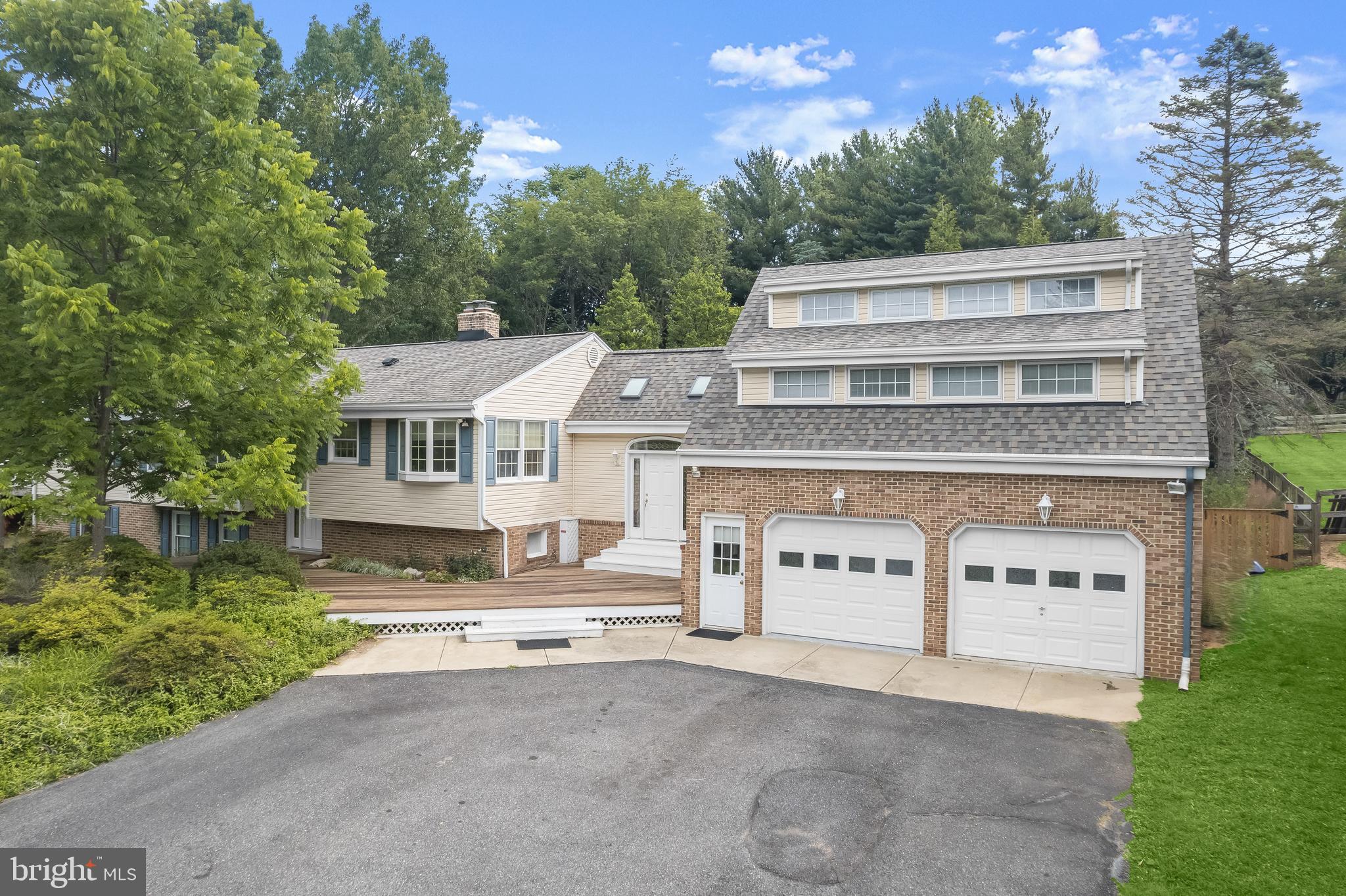 Welcome to 13612 Jacobs Road in Mount Airy, a sprawling split-foyer residence thoughtfully expanded to provide exceptional space and flexibility with four bedrooms and three full baths. Situated on over an acre of beautifully landscaped grounds, this home blends comfortable everyday living with distinctive architectural character and versatile spaces designed to accommodate a variety of lifestyles.
The main level features an inviting eat-in kitchen equipped with crisp white cabinetry, a breakfast bar, and a charming breakfast room with built-ins. Just beyond, the dining room offers direct access to the deck, creating a seamless setting for indoor and outdoor gatherings. The primary bedroom includes multiple closets and convenient access to the full bath, while a cozy sitting room with hardwood floors leads to the impressive great room. This standout space showcases soaring ceilings with exposed beams, multiple sliding glass doors that open to the wraparound deck and enclosed gazebo, and a striking spiral staircase connecting to the lower level.
The lower level expands the home’s living space with a recreation room, laundry room, full bath, two additional bedrooms, and flexible areas ideal for hobbies, entertaining, or extended living. Access to the covered patios further enhances the home’s indoor-outdoor lifestyle.
On the opposite side of the home, a separate entrance leads through a breezeway with access to the rear patio and to an upper-level apartment-style suite. This private space features a fourth bedroom with soaring ceilings, a walk-in closet, full bath, and a comfortable living room ideal for guests, multigenerational living, or a dedicated workspace. Notable updates include Updated main heat pump 4-10-24, 3rd heat pump far left addition 2025, garage floor coating 1-3-25, and  water softener 2025.
 Additional highlights include an attached garage currently configured with two workshop areas, extensive landscaping, a wraparound deck, covered patios for outdoor enjoyment, solar panels, and an extended driveway offering ample parking. With its generous layout, unique architectural features, and peaceful setting, this Mount Airy property presents a wonderful opportunity to create a home tailored to your lifestyle.
Some photos have been virtually staged.
*** Seller is removing solar panels and is replacing the roof and all skylights. Work is scheduled to be completed prior to settlement ***