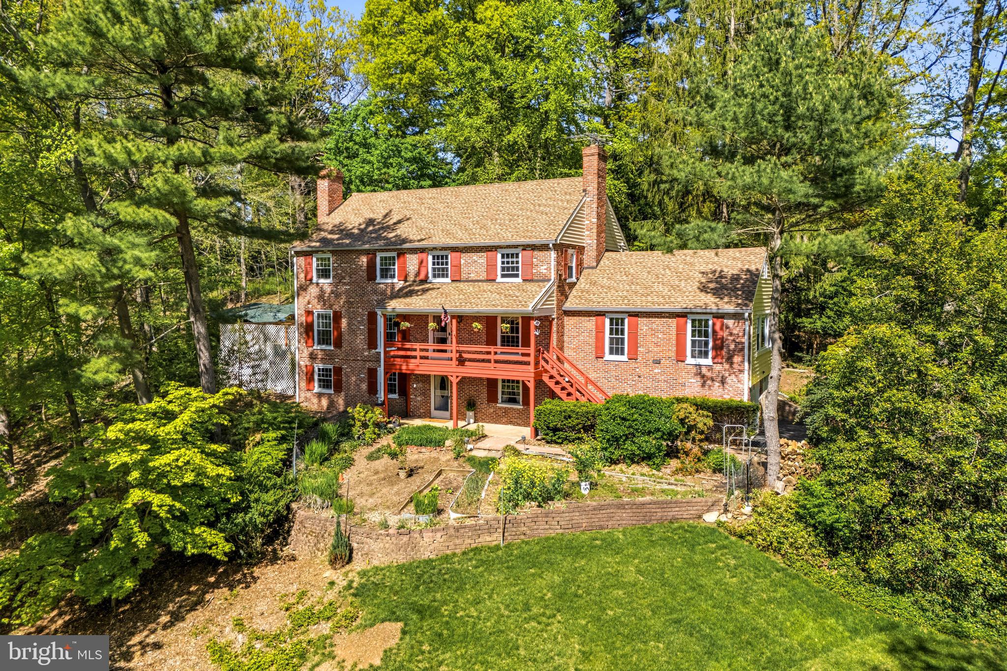 Welcome to 407 Margo Lane, ideally situated in Berwyn’s highly sought-after Woodlea neighborhood. This classic brick Colonial offers 5 bedrooms, 3.5 baths, and approx. 4000 sq ft of interior living space.  This thoughtfully designed layout  blends timeless character with everyday comfort and showcases sweeping sunset views from the inviting front porch.
A center hall foyer with staircase entry sets the tone, opening to spacious, light-filled living areas. The formal living room features a fireplace and flows seamlessly into the dining room, accented with chair rail detailing and perfectly positioned for gatherings. The expansive kitchen is the heart of the home, offering granite countertops, natural wood cabinetry, recessed lighting, and generous workspace for cooking and entertaining. Just beyond, a sun-drenched great room showcases built-in shelving, windows on all sides, and a brick fireplace with gas line hookup—creating a warm and welcoming space year-round.
The main level also offers exceptional versatility with a private office or study, a bright sunroom, a convenient laundry room with access to the rear patio, and a powder room. Indoor and outdoor spaces connect effortlessly, with access to a screened-in porch and side deck with over 600 Sq. Ft—ideal for relaxing or entertaining.
Upstairs, the primary suite provides a comfortable retreat with a walk-in closet featuring built-in organizers and an en-suite bath with double vanity and shower. Four additional spacious bedrooms and a well-appointed hall bath complete the second floor. A walk-up attic with a cedar closet presents excellent storage or future expansion potential.
The full, walk-out lower level adds even more living space, featuring daylight windows, a third fireplace, wet bar, full bath, and flexible areas for recreation, guests, or home gym. This level also provides access to storage, utilities, and the attached side-entry two-car garage with flat driveway.
Recent updates—including a newer roof and gutters, replacement windows, and updated heating and central air systems—offer peace of mind. 
Don’t miss this exceptional opportunity in the heart of the Main Line. This property combines timeless appeal offering bright, inviting spaces and effortless livability. Perfectly positioned near award-winning schools, the vibrant town of Berwyn, and major transit routes and R5 train line. Simply put, this home delivers both a fantastic lifestyle and location.
