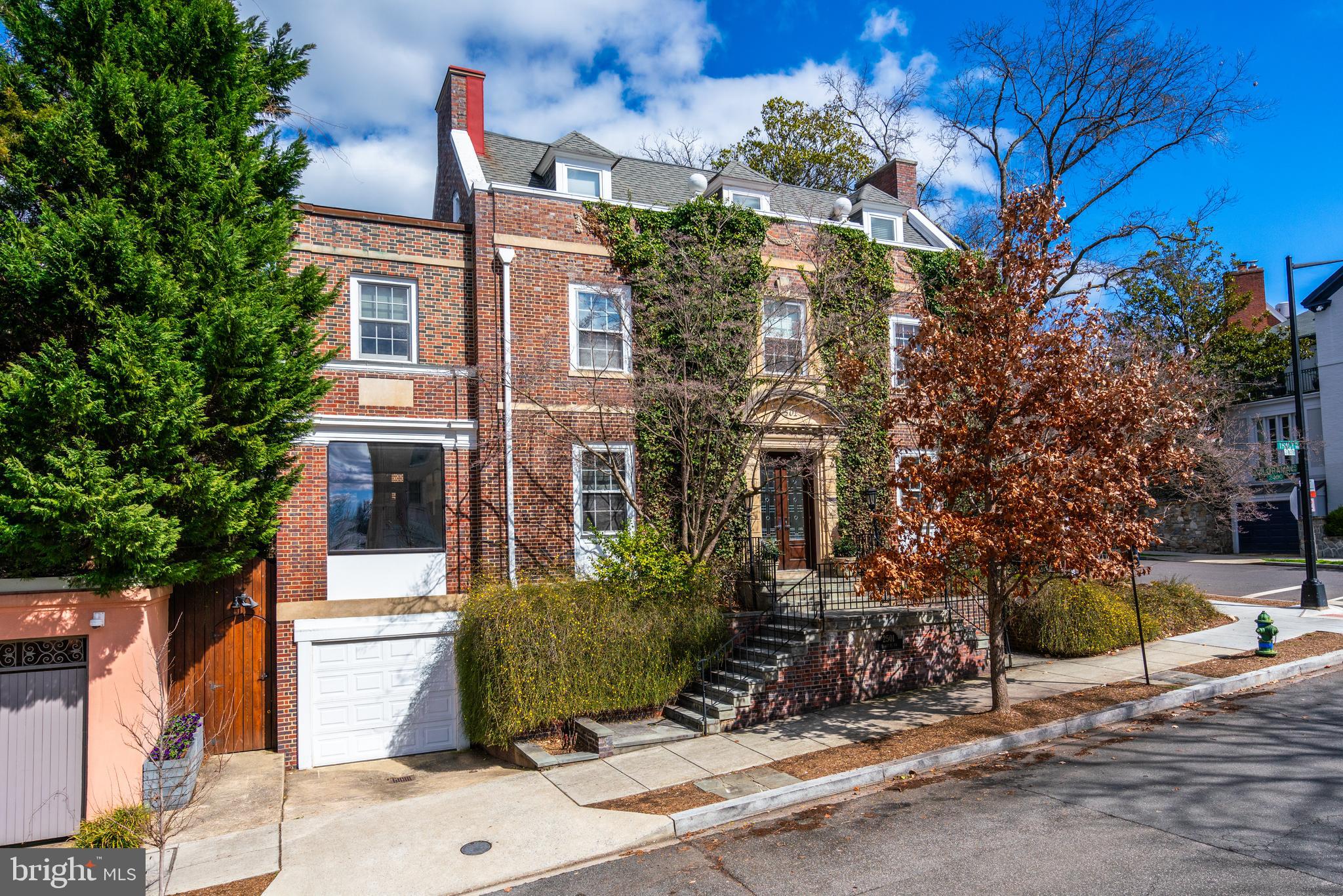 Ideally located in the prestigious Kalorama neighborhood, known for its grandeur, diplomatic residences, and historical significance, this exquisite detached residence is drenched in natural light and seamlessly blends elegant historic character with updated modern finishes. The charming marble vestibule leads into the gracious foyer, complete with a convenient double coat closet. The foyer opens to the living room, which is crowned with a plaster medallion and stunning stain glass windows. The elegant room is centered around a wood-burning fireplace and French doors lead to a beautiful terrace, which is perfect for entertaining. The nearby dining room is sophisticated and offers direct access to the gourmet kitchen. The stunning kitchen, a masterpiece of design by sagartstudio, showcases a juxtaposition of light and dark elements including custom Varenna Poliform cabinetry, large ceramic floor tiles, and Silestone countertops. The impressive eat-in kitchen also features a peninsula with barstool seating, top-of-the-line Wolf and Miele appliances, and a sunny breakfast room that opens to the intimate garden outside. On the same floor, there is an easy flow to the spacious sunroom/family room, which is outfitted with ample custom Poliform cabinetry and Kreon lighting. The room has oversized windows and glass doorways that connect the interior space to the lush environment and terrace space outside. The second story has a beautiful library, replete with abundant built-ins, custom cabinetry, and a second fireplace. This floor includes two en-suite bedrooms, including the spacious primary bedroom which overlooks the serene garden. The primary suite is a haven of luxury, boasting multiple walk-in closets and an en-suite bathroom with a jacuzzi tub, dual vanities, and a frameless glass shower.  The top floor offers two additional light-filled bedrooms with high ceiling and a well-appointed hall bathroom. Additionally, the lower level acts as a fully separate area with its own entrance, featuring one bedroom, one bathroom, and a dedicated kitchen and living space – ideal as an au pair suite, for guests, as a gym, and/or office.  The garage is full-size and has additional storage. The gardens of the property offer the utmost privacy. There are multiple terrace spaces ensconced by layered landscaping and accompanied by calming water features. The outdoor space provides a beautiful backdrop that is wonderful for entertaining or tranquil relaxation. The house is within close walking proximity to Georgetown, Dupont Metro, Adams Morgan, and a variety of noteworthy and popular restaurants, shops, and cultural experiences. The neighborhood is also surrounded by a number of parks, biking/hiking trails, and green spaces including Mitchell Park, Kalorama Park, and Rock Creek Park.