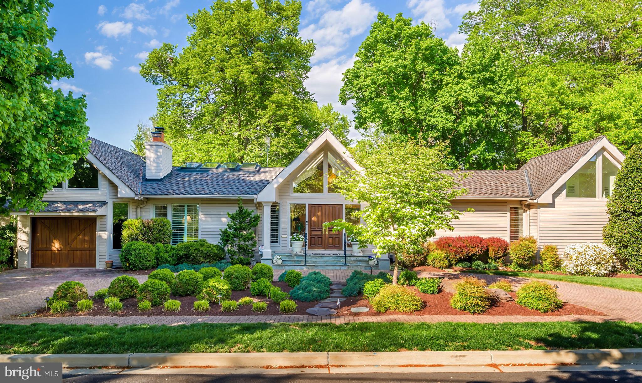 Why buy a condominium or townhouse when you can have this Chevy Chase charmer with first floor primary! Prepare to be dazzled by this beautifully updated Craftsman-style home in Chevy Chase, MD! The perfect alternative to a condo or townhome with a first floor Primary Suite with  two full bathrooms.  Beautifully landscaped grounds give you an indication of what awaits you inside. The covered entry 's double doors with glass side windows and triangular clerestory above open to the magnificent foyer with its vaulted ceiling and skylights, setting the tone for the magnificent, light-filled interior, which is ideal for large- or small­ group entertaining as well as comfortable family living. There are soaring ceilings throughout much of the main level; recessed lights; natural, reclaimed hardwood floors in many rooms; and plentiful windows offering views of the beautiful, landscaped grounds.
The main level offers an open floor plan, which is so popular in today's homes. The Living Room has a vaulted ceiling with skylights and a handsome wood-burning fireplace flanked by Open shelving and cabinets. It is adjacent to a large Dining Room with a cathedral ceiling and skylights, which in turn opens to a Solarium with cathedral ceiling, skylights, an extended window seat with windows and skylights above, and a sliding glass door to the extended Patio. The generous-sized Kitchen has plenty of space for the serious cook with plentiful white wood cabinets and a custom tile backsplash, stainless-steel appliances, a pantry closet, wet bar, and a sliding glass door to the solarium. A separate Sunroom also boasts a cathedral ceiling with skylights and opens to the Patio as well as the Garage.
The bedroom wing is where you will find the Primary Bedroom Suite. The Bedroom has two closets, attic access, a wall of windows, and sliding glass doors perfect for a future deck.
Prepare to luxuriate with two Primary Baths! The larger one features an aerated tub and an oversized tiled steam shower with built-in bench, large vanity, mirror with a hidden TV, a separate water closet, large, organized walk-in closet, and marble flooring. The second Bath, with vaulted ceiling and clerestory windows, has a marble pedestal sink with medicine cabinet above, ceramic tile shower with handheld and fixed showerheads, and a built-in niche, and ceramic tile flooring
The second Bedroom, which could also be used as a Study, has picture windows overlooking a Patio and the lovely back yard.
The finished walkout lower level features a spacious Family Room with a wood-burning fireplace and built-in cabinetry on the side. This room has wall-to-wall carpeting.
Bedroom #3 has a wall of closets, sliding glass door to the Patio and an adjacent large Storage Room. Bedroom #4 has a trey ceiling, wall-to-wall carpeting and sliding glass door to the Patio as well. A full Bath has a vanity with medicine cabinet and sconces above, a fully tiled oversized shower with Raindance head and a second hand-held shower head, and tile floor. A Laundry Room and Utility Room complete this level.
The fully finished Garage has a separate Storage Room accessed from the Garage and Patio. The circular driveway of brick pavers provides lots of extra parking.
You will love the well-designed hardscape terrace, which has plenty of room for lounging, dining, and gathering around the firepit throughout the seasons.
Add to all this a wonderful location within walking distance to shops and restaurants on Connecticut Avenue, as well as proximity to Chevy Chase Lake, the Capital Crescent Trail, and the future Purple Line for the Metro. There is easy access to downtown DC with all its many attractions, as well as Bethesda and northern Virginia. Hop on 1-495 if you need to travel out of the area from any of the three major area airports.
This is truly a home for a lifetime!