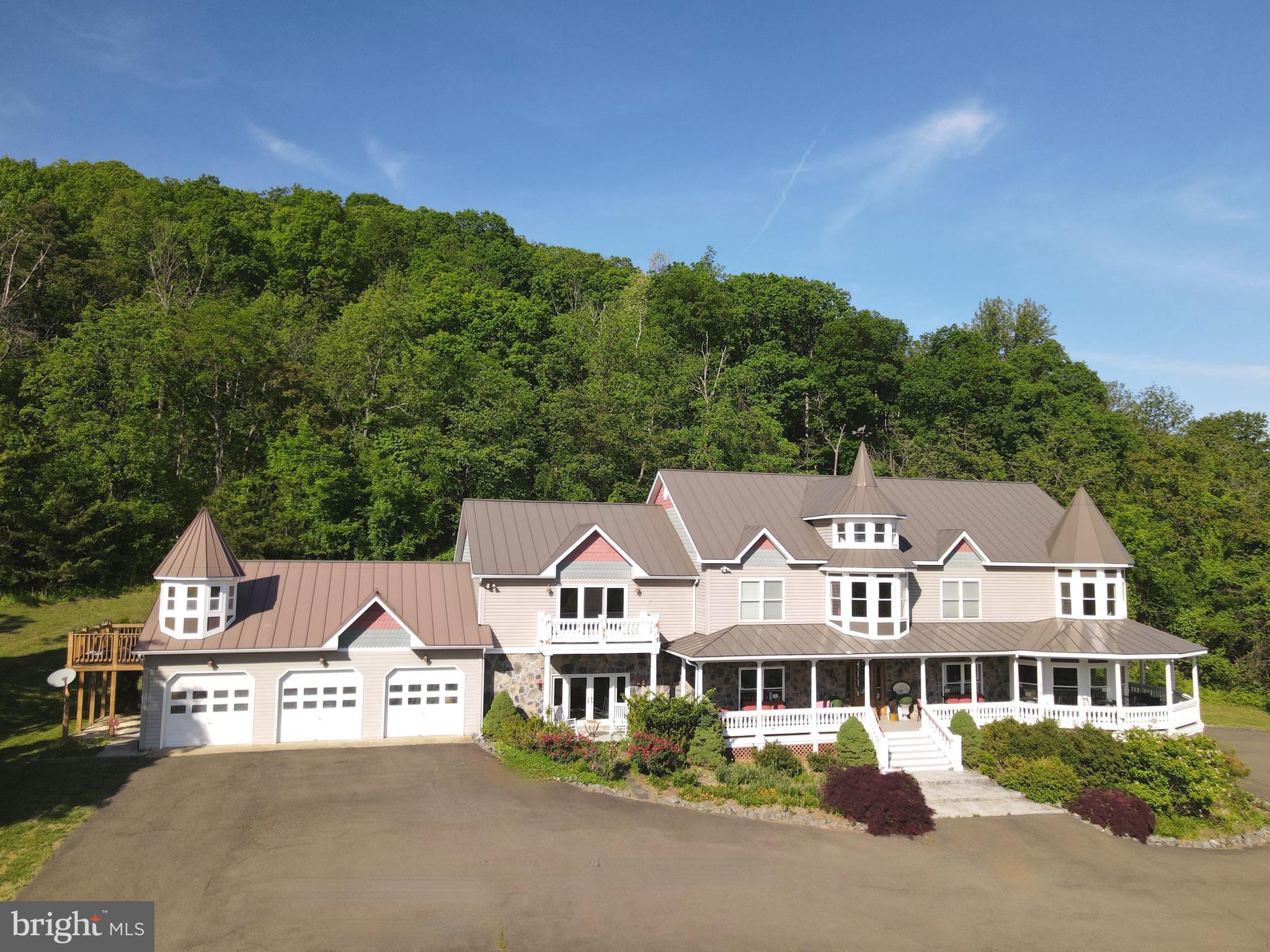 THE ROMANCE of an earlier era, LUXURIES of today and an EFFORTLESS sense of scale await on 29 acres with close by PANORAMIC VIEWS of the Blue Ridge Mountains, the surrounding embrace of the neighboring Shenandoah National Park in the day and the celestial Milky Way at night, all about an hour west of Washington DC.  This delightfully private estate feels less like a property and more like a hidden chapter.  Spectacularly spacious, delightfully livable and filled with ultimate comfort, this home  of roughly 9,600 sq ft unfolds with an effortless sense of scale, designed for living that stretches across generations.  *  Inside spaces are composed with intent.  Sunlit rooms invite slow mornings with coffee and books, fireside corners draw in conversation that lingers long past dusk.  A grand yet welcoming kitchen anchors the home, with generous dining and entertaining areas.  The family room becomes a heartbeat space, equally suited for family traditions, milestone toasts, and the easy chaos of everyone home at once.  A walkout level transforms into a spirited retreat of its own. A bar with kitchen sets the stage for evenings that drift between billiards, ping pong, the crescendo of a big game and laughter echoing just enough to remind you this house was built to be lived in, not tiptoed through.  ******  Six bedrooms are thoughtfully arranged to balance connection with privacy, including two separate private entrance apartments. One apartment attached to the garage offers an ideal two story escape where younger generations can carve out their own world within the larger frame.  The other apartment provides refined independence for your boomers who want to go to bed early and appreciate their own serene retreat.  * Think retirement. Think nature. Think work at home, for this office is more productive than any city office can possibly be. Think easy commute when you must go to town and a multi-generational home if so inclined.  This is not simply a home. It is a place where generations gather, scatter, and return again, each time adding another layer to its story.
