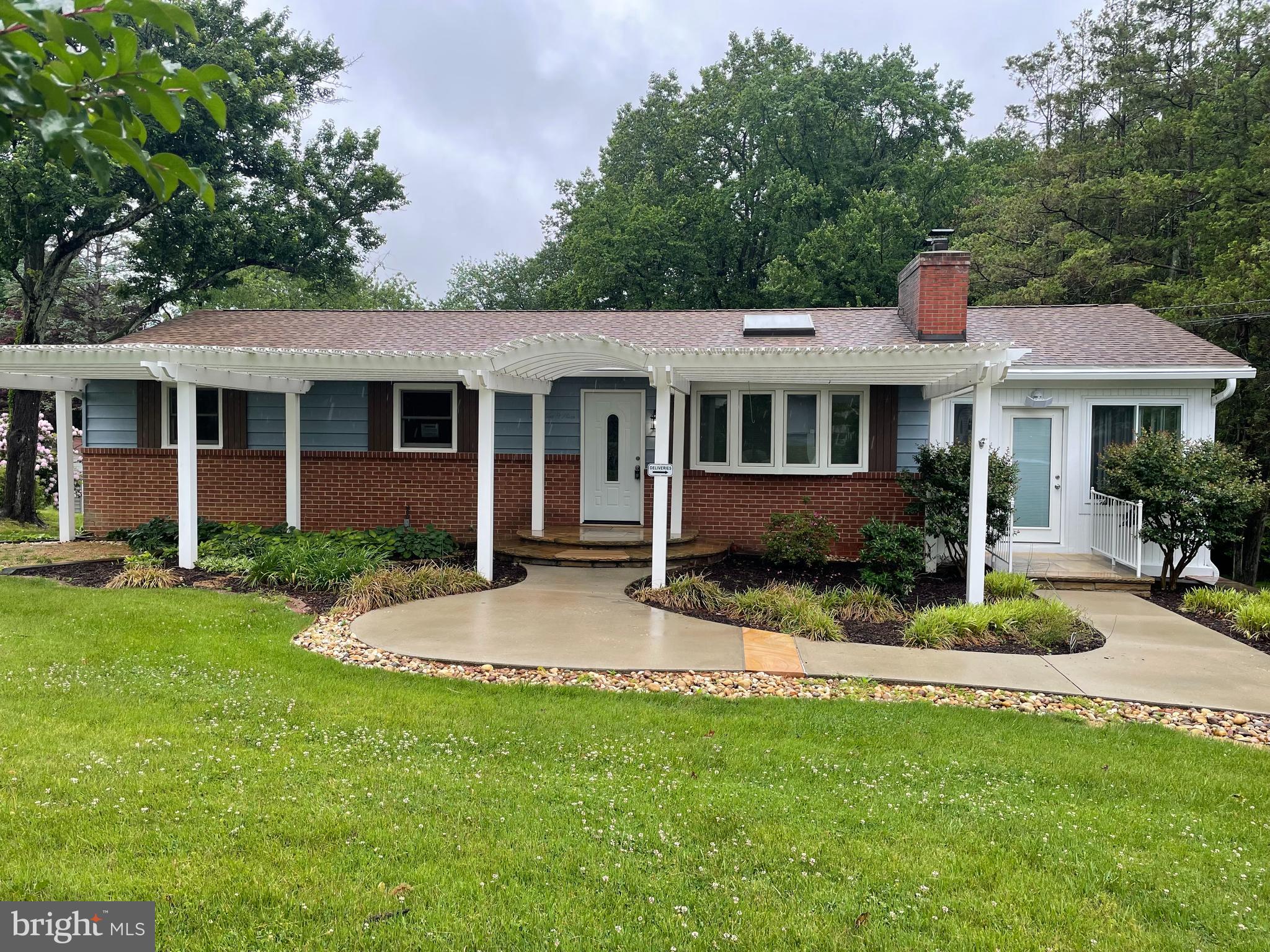 Beautifully updated and expanded home situated on a private 0.67-acre lot in sought-after Ellicott City. This light-filled residence features durable LVP flooring throughout both levels and an open, functional floorplan ideal for everyday living and entertaining. The main level welcomes you with a sunny living room highlighted by a charming bay window that flows seamlessly into the updated kitchen featuring stainless steel appliances, quartz countertops, breakfast bar seating, and an adjacent dining area with French doors leading to the balcony. Just off the kitchen is a spectacular family room surrounded by three walls of windows overlooking the property, with direct balcony access and a separate front entrance—perfect for a private home office, studio, or flex space. Down the hall, the spacious primary suite offers an updated private bathroom with a stylish glass-enclosed shower. Two additional generously sized bedrooms and an updated full hallway bath complete the main level.

The fully finished walkout lower level provides exceptional additional living space, including a large rec room or den with backyard views, a wet bar with an additional refrigerator, a full bathroom, a laundry room, and a separate office/bonus room. Outside, enjoy the expansive lot, long private driveway, and abundant rear parking for multiple vehicles, along with both an attached garage and detached garage for added convenience and storage.  New HVAC.
