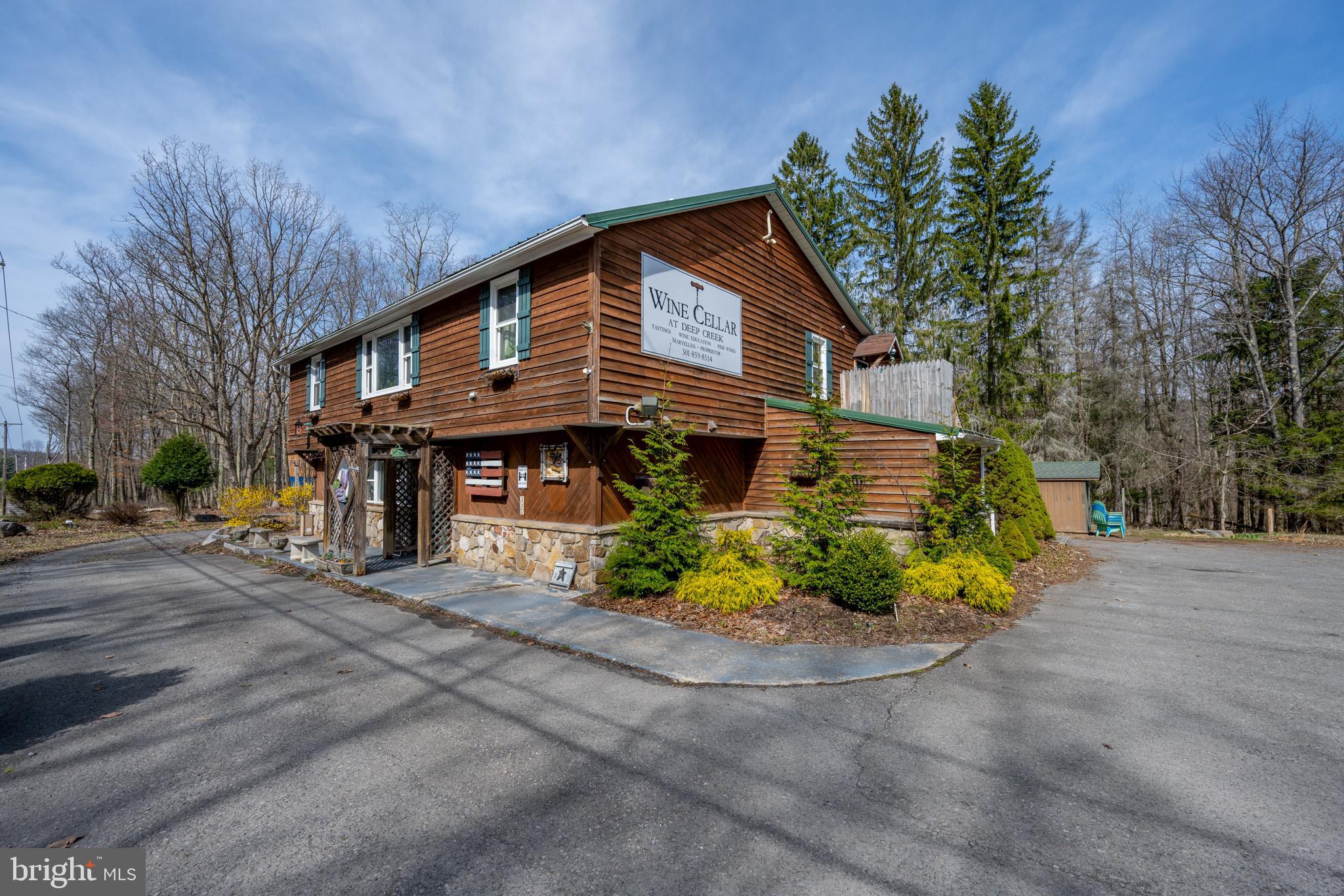 Here is your opportunity to own an awesome commercial location at Deep Creek Lake. Currently being operated as WIne Cellar at Deep Creek. Property is located in residential zoning but has a special exception to run the retail business. Please see email from Planning and Zoning about continued commercial use and also Garrett County Liquor Control Board email regarding liquor license. Large 2BR/2BA apartment on the second level so you could run the business and have a place to live also. Massive stone fireplace on the lower level, commercial kitchen including walk in cooler, Men's and Women's restrooms. Plenty of space for restaurant, retail, etc. Owner would consider selling the business and inventory as they are negotiable. Well is shared with neighboring property. RAILEY REALTY IS NOT THE CARETAKER OF PROPERTIES LISTED BY IT. DURING INCLEMENT WEATHER CONDITIONS, PROSPECTIVE PURCHASERS AND THEIR AGENTS ASSUME ALL LIABILITY ASSOCIATED WITH OR BY WEATHER AT THE PROPERTY.