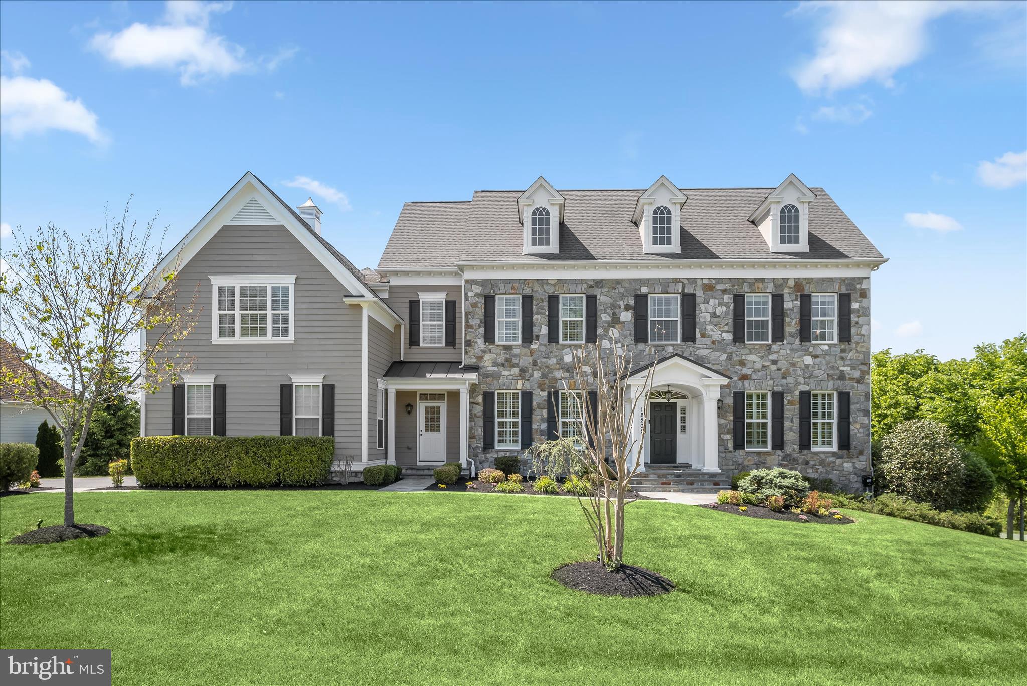 Offer Deadline Tuesday, May 19 at 6PM. Discover luxury living in this extraordinary colonial nestled on a private corner lot spanning over an acre in the highly sought-after River Hill area of Fulton in Howard County. Originally the model home for the community, this exceptional residence showcases the highest level of sophistication, timeless architectural details, and endless opportunities for entertaining and everyday living with whole-house speakers. Arrive through the grand two-story foyer and experience a dramatic curved staircase, soaring ceilings, craftsman crown molding, box wainscoting, and gorgeous hardwood flooring that flows throughout the main level. The formal living and dining rooms elegantly welcome guests with custom ceiling details, plantation shutters, classic columns, chair railing, and refined box wainscoting. Beyond the private French door office accented by crown molding and double chair railing, discover a thoughtfully designed mudroom with built-in storage, a beautifully appointed laundry area, and access to the expansive three-car garage. The gourmet kitchen is the heart of the home, boasting a spacious center island with breakfast bar seating, abundant counter space, ceramic tile backsplash, 42” soft-close cabinetry with pull-out drawers, stainless steel appliances, and a bright breakfast area. The attached sunroom elevates the experience with designer ceiling details, elegant tile flooring, a built-in bar area, and direct access to the deck overlooking protected conservation views. The adjoining family room is equally impressive, featuring a modern gas fireplace surround, custom built-in bookcases, abundant natural light, and a tray ceiling accented with crown molding. A convenient back staircase provides seamless access to the upper level, where the luxurious primary retreat awaits. Designed as a tranquil, spa-inspired sanctuary, the primary suite offers a private sitting area with a wet bar and balcony access, plush carpeting, dual walk-in closets, a tray ceiling with crown molding, gas fireplace, in-ceiling speakers, and a lavish en-suite bath complete with soaking tub, separate vanities, water closet, and a double-entry walk-in shower with dual fixtures and stunning glass and ceramic accents. The upper-level south wing is thoughtfully designed with an ideal blend of bedrooms, baths, and workspaces, including two spacious bedrooms with walk-in closets connected by a dual-entry bath with double vanity and a custom desk area that separates the third bedroom and full bath. An additional private bedroom suite with a walk-in closet and en-suite bath completes the upper level. The fully finished lower level expands the living space with endless versatility, offering plush carpeting, a wet bar with dishwasher, a beverage cooler, and abundant storage. The custom wainscoted game area leads to a private bedroom, gym, and theater room. At the same time, the lounge with built-in seating opens directly to the patio and fire pit area for seamless indoor-outdoor entertaining. Ideally located near MD-32, US-29, and I-95, this remarkable residence provides convenient access to Washington D.C., Baltimore, Columbia Mall, Merriweather Post Pavilion, BWI Airport, and countless shopping, dining, and entertainment destinations.