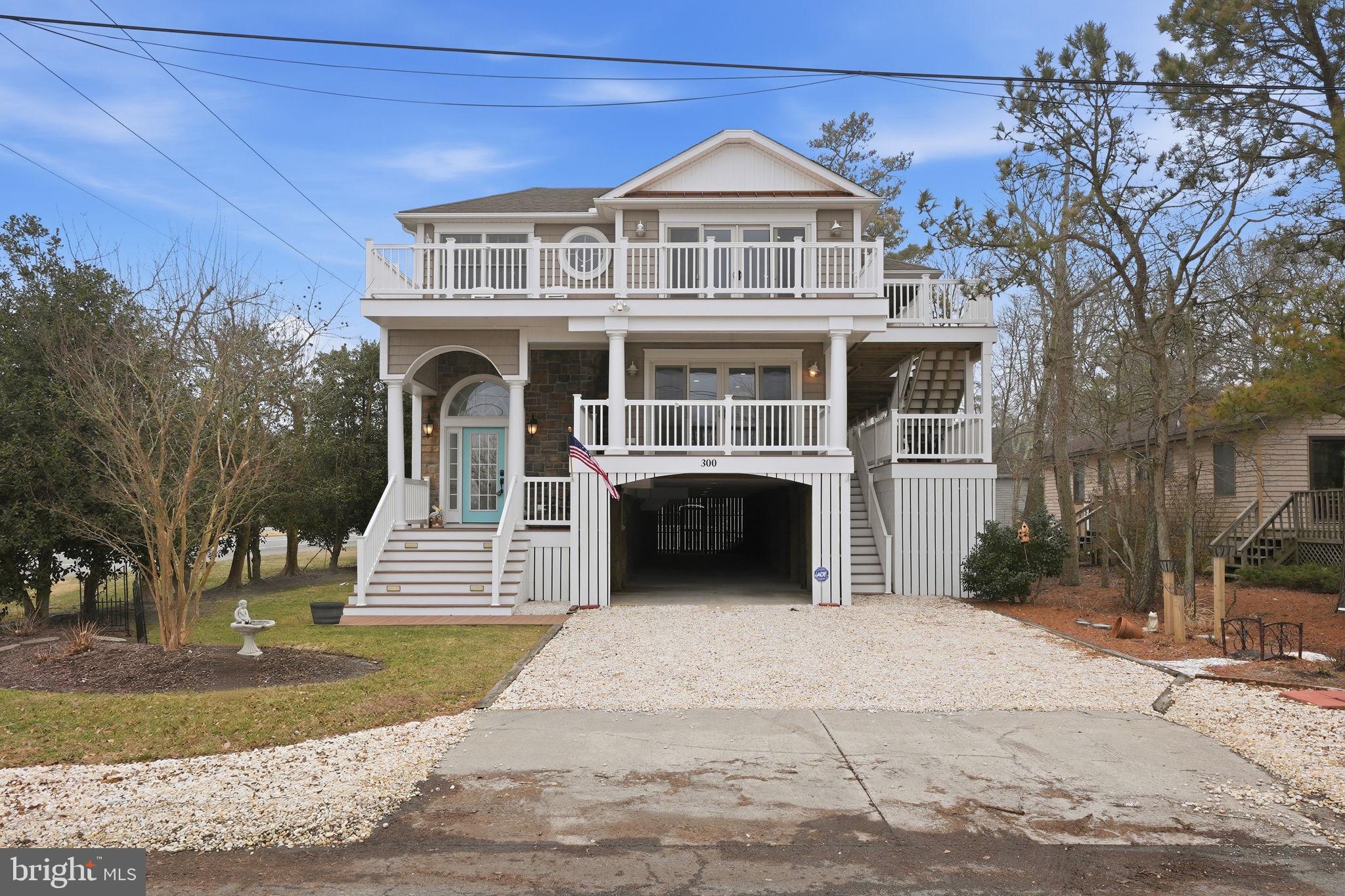 Just two blocks from the sand and an easy stroll to the shops, restaurants, and boardwalk of Bethany Beach, this spacious coastal retreat built in 2013 offers over 3,300 square feet of bright and inviting living space designed for relaxed beach living.

With 5 bedrooms and 4 full bathrooms, the layout provides plenty of room for family and guests. The main level features the first family room, creating a comfortable space to gather after a day at the beach. This level also includes one of the home’s two primary suites with a private en suite bathroom, along with two additional bedrooms and another full bathroom.

A dramatic two story foyer staircase leads to the second level where the main living area is filled with natural light from walls of windows. Here you will find a large family room, a spacious gourmet kitchen with a center island and breakfast seating, and a separate dining room ideal for hosting gatherings. The second primary suite offers another private en suite bathroom, while an additional bedroom is served by a convenient dual entry full bath.

Outdoor living is just as impressive. Enjoy coastal breezes from the screened porch, relax on the expansive wraparound covered deck, or soak up the sun on the open wraparound deck perfect for sunbathing. The fenced backyard offers ample space for a future pool, while the oversized attached carport provides room for four or more vehicles, secure temperature controlled storage, and an outdoor shower for easy beach days.

An exceptional beach home in a prime location near the heart of Bethany Beach, offering generous space, multiple living areas, and fantastic indoor and outdoor gathering spaces. Sold fully furnished except for staging decorative items and artwork listed in disclosures.
