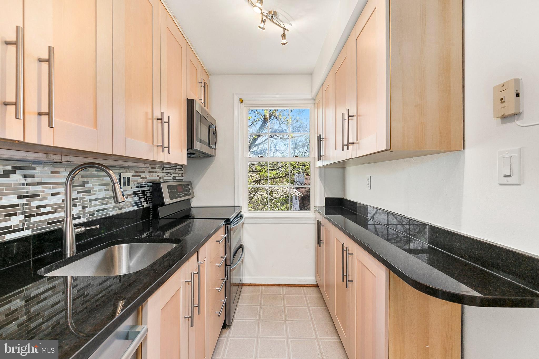 Welcome home to 2211 Washington Ave, Unit 303, in the desirable Rock Creek Commons community of Silver Spring. This freshly painted 2 bed, 1 bath condominium offers comfortable living with thoughtful updates and stylish finishes throughout. The kitchen features granite countertops, stainless steel appliances, an electric range with double ovens, convection microwave, stainless steel and glass backsplash, track lighting, and vinyl flooring, along with attractive cabinetry and under-cabinet lighting by the sink. The adjacent dining area showcases hardwood floors with chair rail and crown molding, creating an elegant space for everyday meals or entertaining. The bright living room also features hardwood flooring, while both bedrooms offer carpeting and generous closets. Bedroom two is enhanced by crown molding and built-in bookshelves flanking the windows, adding character and functionality. The full bath includes a ceramic tile floor and surround with an updated tub liner, and additional storage is provided by a convenient pantry closet. A stackable, frontloading washer and dryer replaced in January 2025 adds everyday convenience, the condo is wired for Fios, and the home also benefits from updated windows. Conveniently located close to Rock Creek Park’s trails, as well as nearby shopping, dining, and entertainment in downtown Silver Spring and Kensington. Easy access to Metro, MARC, major commuter routes, and Washington, D.C. Combining comfort, updates, and a prime location, this home offers exceptional value in a vibrant Silver Spring setting.***MORTGAGE SAVINGS MAY BE AVAILABLE FOR BUYERS OF THIS LISTING.***