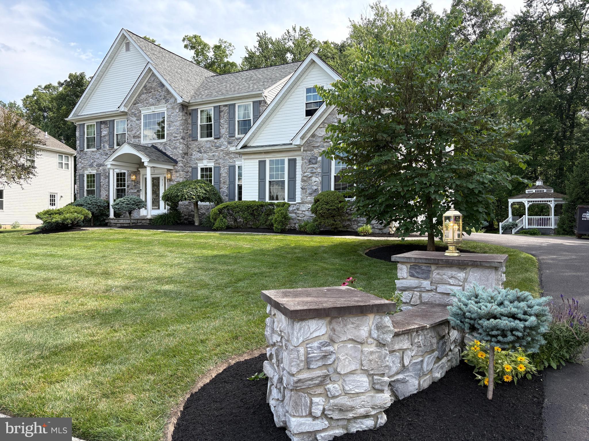 Nestled on a quiet cul-de-sac in the highly desirable Somerset Walk community, this meticulously maintained residence offers an exceptional blend of timeless elegance, comfort, and convenience. Backing to tranquil woods and preserved open space, the beautifully landscaped property showcases outstanding curb appeal with paver walkways leading to the welcoming covered front porch and continuing around the rear of the home, creating a picturesque setting to enjoy throughout every season. Lovingly cared for by its original owners, this move-in ready home reflects pride of ownership at every turn. A dramatic two-story foyer with a graceful turned staircase and 9-foot ceilings throughout the main level creates an impressive first impression. Gleaming hardwood floors enhance the private home office, formal living room, and elegant dining room, where thoughtfully designed spaces flow seamlessly for both everyday living and sophisticated entertaining. The heart of the home is the beautifully appointed kitchen, featuring 12-inch ceramic tile flooring, abundant 42-inch cabinetry, granite countertops, a center island, and a bright breakfast area overlooking the private backyard. The kitchen opens effortlessly to the inviting family room, highlighted by a cozy fireplace, while the adjoining formal living and dining rooms create an ideal layout for hosting gatherings of any size. Sliding glass doors from the breakfast area lead to an expansive deck overlooking the manicured grounds and charming gazebo—perfect for morning coffee, alfresco dining, or simply relaxing while enjoying the peaceful wooded backdrop. A spacious laundry room and powder room complete the main level. The professionally finished lower level significantly expands the home's living space, offering custom built-ins, a second powder room, and a versatile bonus room ideal for a home office, fitness studio, hobby room, or creative workspace, providing exceptional flexibility for today's lifestyle. Upstairs, the luxurious primary suite serves as a peaceful retreat, accessed through double doors and featuring a vaulted ceiling, comfortable sitting area, and two generous walk-in closets. The spa-inspired primary bath is appointed with a marble double vanity, corner soaking tub, and separate shower. Three additional bedrooms are bright and generously sized, each offering ample closet space and sharing a well-appointed hall bathroom. Additional highlights include a two-car side-entry garage, beautifully maintained landscaping, premium wooded views, and an ideal location within the award-winning Central Bucks School District. Just minutes from major commuting routes, shopping and dining at Valley Square, local parks, and Lions Pride Park, this exceptional property offers the perfect balance of privacy, natural beauty, and everyday convenience. With its premium setting, impeccable condition, elegant finishes, and highly sought-after location, this distinguished Somerset Walk residence presents a rare opportunity to enjoy refined Bucks County living at its finest.