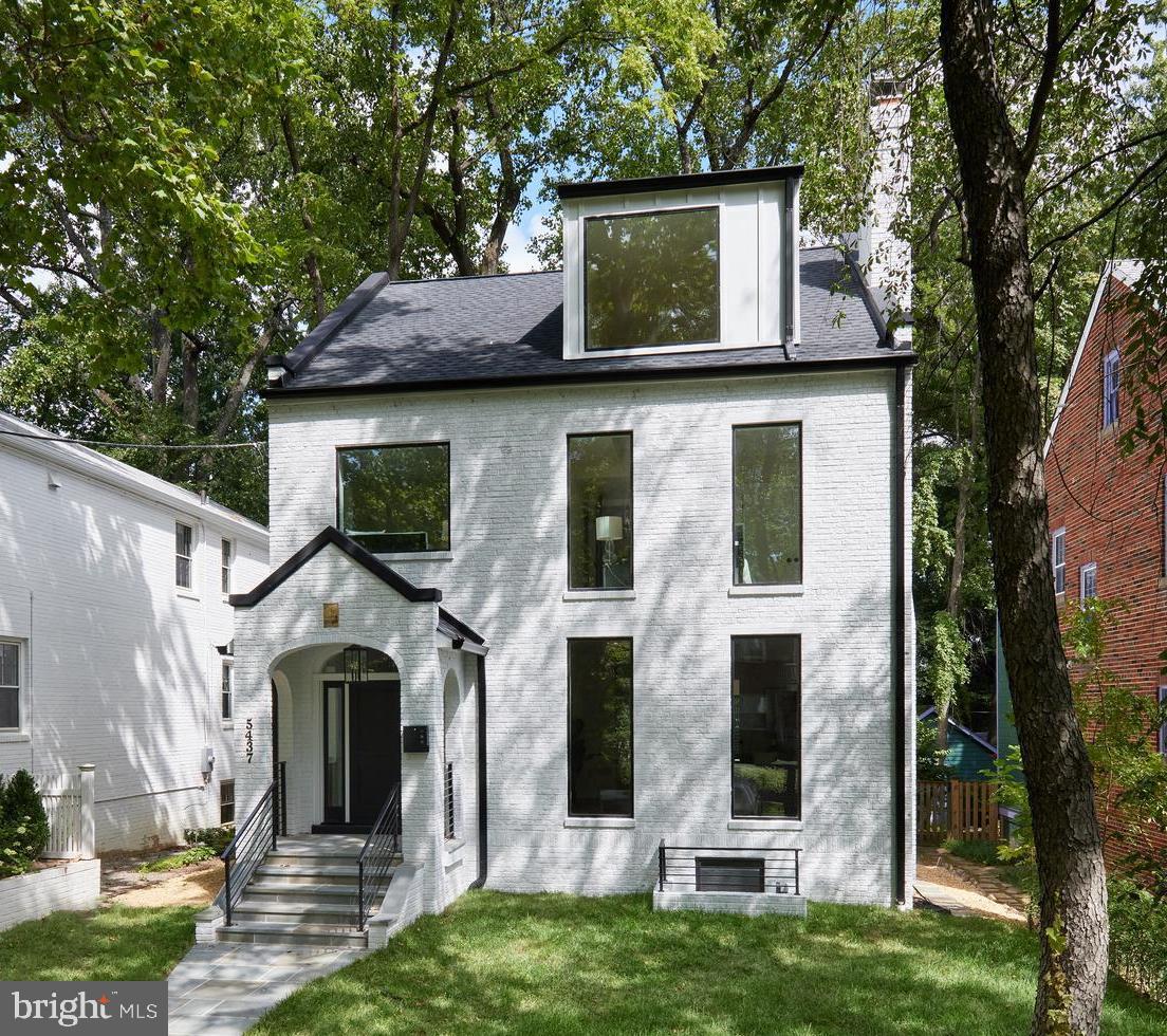 Reimagined, expanded, and beautifully redesigned, this exceptional new construction home in Chevy Chase harmoniously blends contemporary finishes with classic colonial charm. With a balance of defined rooms and an open-concept kitchen/family room, it offers the perfect mix of modern living and timeless elegance. Interiors by JDM Design Studio.
The main level boasts refined herringbone floors, a welcoming side entry hall, a formal living room with a wood-burning fireplace, a dining room, and a whimsical powder room. The gourmet kitchen seamlessly connects to the spacious family room, which opens to a rear Ipe deck with access to the fenced backyard and  a 12' x 20' off-street parking pad, wired for an EV charger.  
The second level hosts four bedrooms and three bathrooms, including a luxurious primary suite with a spa-inspired bathroom and a large walk-in closet. This level also features a dual-entry laundry room and two additional full bathrooms serving three bedrooms.
The top level is a show-stopper with its lofted ceilings, an additional bedroom or office, a full bathroom, and a family room with soaring 14-foot ceilings, a covered Ipe deck with a wood ceiling and a gas line for grilling enhances the outdoor space.
The walk-out  lower level provides even more living space, including a full bedroom, bathroom, second laundry room, recreation room, and mudroom with direct access to the parking pad and backyard.
Ideally situated just five blocks from the shopping, dining, and retail options on Connecticut Avenue, and three blocks from Lafayette Elementary and Broad Branch Market, this home also offers stunning winter views of the Cathedral from the second and third levels.