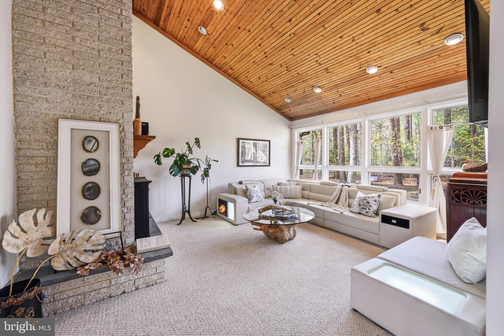 A fresh new price – now offered at $699,000.  A light-filled entertainer’s dream with soaring vaulted wood ceilings and seamless indoor-outdoor living, this beautifully maintained four-bedroom contemporary is privately situated on a one+ acre lot overlooking the 12th fairway of the Links at Perry Cabin golf course.   The inviting interior features a dramatic vaulted living room with fireplace and wood-burning insert, spacious family and dining rooms, and a bright sunroom that opens to a relaxing private deck ideal for entertaining or quiet everyday living.  
The main level primary ensuite includes two walk-in closets and new carpeting installed in 2024, creating a comfortable private retreat.  Significant 2024 improvements include a new roof and gutters, representing approximately $90,000+ in recent upgrades. Double-pane windows throughout enhance energy efficiency and create a peaceful interior environment.  Home is supported by three HVAC systems professionally serviced and maintained by Shaw's along with two water heaters for enhanced comfort and efficiency. Nestled within a wooded setting offering both privacy and scenic golf course vistas. The two-car garage provides abundant space for hobbies, storage, or workshop use, while the expansive driveway comfortably accommodates 7+ vehicles.  Enjoy quiet golf course living just minutes from historic St. Michaels, restaurants, shops and the waterfront.