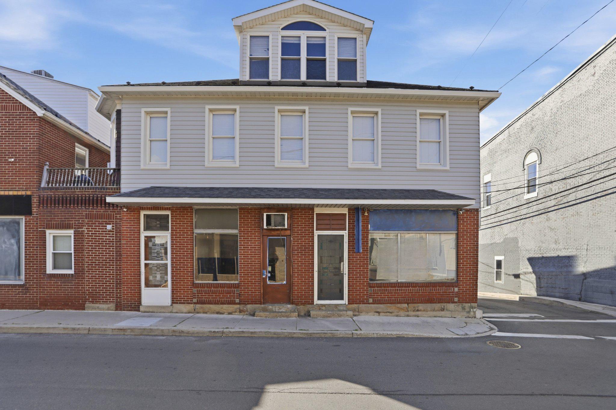Rare opportunity to own an entire half block of Frostburg history in the Historic District. Comprising 8, 10, and 12 South Broadway, this unique mixed-use property offers exceptional potential for investors, entrepreneurs, and owner-occupants alike.

For more than 50 years, this building was home to a beloved local bakery, and now it's ready for its next chapter.

8 S. Broadway provides access to the spacious residential living quarters featuring a living room, dining room, kitchen, den, 2 bedrooms, and 1.5 baths. The den could easily serve as a third bedroom, home office, or flex space.

10 S. Broadway was formerly the bakery's retail storefront. This space includes a half bath and a former cake room that could be converted into a galley kitchen, creating the potential for an additional rental unit or expanded commercial use.

12 S. Broadway housed the bakery operations. All equipment has been removed, leaving a blank canvas for your vision. Plumbing connections remain in place for future sink and bath fixtures, making this space ideal for a new business, studio, office, retail venture, or efficiency apartment conversion.

The commercial portion benefits from an existing fire suppression system and utility hookups suitable for many food and beverage operations, while also offering flexibility for retail, office, service-based businesses, and more.

The residential space features beautiful hardwood floors, a bright bay window, abundant natural light, cedar closets, convenient laundry, a half-bath ensuite, and an expansive third-floor loft that offers even more living or storage space.

Whether you're looking to open a business, create multiple income-producing units, or live where you work, this property presents a unique opportunity in a thriving downtown location surrounded by established businesses and just steps from Main Street.

Property is being sold AS-IS. Remaining equipment will be removed prior to closing. Schedule your showing today and bring your vision to life!