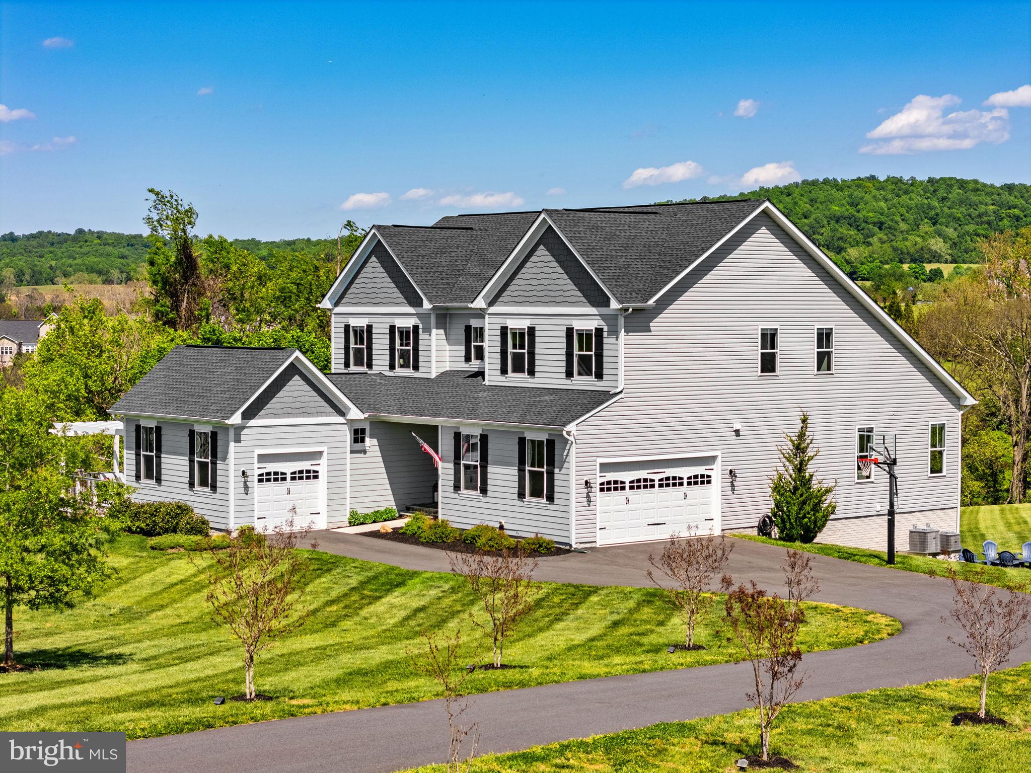 Welcome to the desirable Waterford Manor community, this exceptional estate offers a rare blend of refined luxury and serene countryside living, just minutes from historic downtown Leesburg, yet beautifully set within the rolling landscape of Waterford. If you've been looking for the perfect multi-generational home, this is it. 

Positioned on over three acres of sweeping, panoramic grounds, this distinguished Weymouth model presents a thoughtfully curated living experience defined by scale, light, and architectural elegance.

The expanded main level, enhanced by a 4-foot extension, unfolds with vaulted ceilings, abundant natural light, and a striking fireplace, creating a sophisticated yet inviting atmosphere. At the heart of the home, the gourmet kitchen is designed to impress, featuring two oversized islands, premium finishes, and seamless flow for both intimate gatherings and grand entertaining. The main-level primary suite serves as a private retreat, highlighted by dual walk-in closets and an abundance of natural light, with tranquil views that bring a sense of calm and connection to the surrounding landscape.

A standout feature of the home is the private multi-generational suite, thoughtfully designed with its own kitchen, full bath, washer and dryer, and dedicated garage access, ideal for extended living, guests, or a private workspace. This space is further enhanced by direct access to a private deck and pergola, offering a peaceful outdoor extension perfect for quiet mornings or evening unwinding.

Upstairs, four well-appointed bedrooms provide comfort and flexibility, including one with a private en-suite. A secondary laundry area and an open loft space enhance everyday functionality, while open rail staircases and upgraded trim and door selections contribute to the home’s custom, elevated aesthetic.

The lower level continues the home’s expansive footprint, offering a spacious recreation room, full bath, and a framed option for a future seventh bedroom, allowing for seamless expansion as needs evolve. Recent updates include new carpeting throughout the lower level and staircases, as well as the addition of a tankless water heater.

Outdoor living is nothing short of exceptional, with over $55,000 invested in premium all-weather decking and a custom pergola, creating a stunning setting for outdoor entertaining or quiet relaxation. The property is further enhanced by a mostly flat, usable landscape and a charming creek feature, adding both natural beauty and a sense of tranquility rarely found at this level of convenience.

This is a rare opportunity to own a distinctive, thoughtfully upgraded estate in one of Western Loudoun’s most coveted communities, where privacy, design, and lifestyle converge effortlessly.