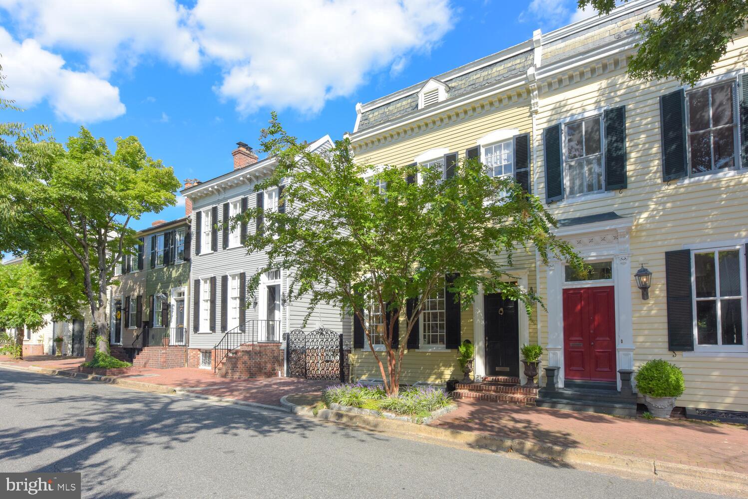 Prepare to be charmed by this pretty, plaqued townhouse, ideally located in the heart of Alexandria's historic district.  Period details and modern conveniences are apparent throughout. 320 South Lee Street was a welcome addition to Historic Garden Week's Old Town Tour.   Special features include an elegant, light-filled living room with eleven foot ceilings and a handsome fireplace.  The dining room, with a custom, built-in china cabinet, easily hosts a dinner for eight. The custom kitchen is designed with the cook in mind, outfitted with top quality cherry cabinetry  and top tier, stainless steel appliances, including a 6 burner Viking range.  A coveted family room is especially inviting, with its wood-burning fireplace, handsome built-in bookcases, a lovely powder room tucked in and a full sized coat closet. French doors, flanked by floor to ceiling windows bring year-round views to the private walled garden filled with established boxwoods and mature perennials.  The second floor offers three flexible bedrooms. The primary bedroom includes a third (decorative) fireplace and easily accesses a fully renovated bath with a deep soaking tub, seamless glass doors and custom-crafted marble and chrome sink.  The second bedroom, currently used as a cozy study, is easily accessed by the front or rear staircase.  The third bedroom hosts extra-large closets and a marble clad, en-suite bath with a full sized, walk-in shower and free form glass and chrome sink.