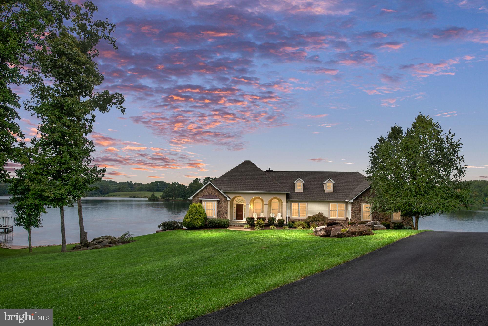 Welcome to your slice of paradise on Lake Anna’s exclusive private side with gorgeous panoramic lake views and unforgettable sunsets! This exquisite waterfront home is a testament to luxury living, offering an unparalleled blend of comfort, style, and natural beauty. Nestled in the premier Mill Run subdivision on a premium peninsula lot boasting an impressive 441 feet of waterfront - the longest in the neighborhood!
As you approach the house, you'll be struck by its commanding presence and the meticulously landscaped grounds. The property is thoughtfully enclosed on two sides by a 4-foot-high black aluminum fence and for your furry friends, an invisible fence system is already in place, allowing them to roam freely and safely.
Step inside, and you'll be greeted by a spacious interior spanning 4,300 finished square feet, with an additional 800 square feet of unfinished space for future customization which is currently being use for a workshop and storage. The main floor is a masterpiece of design, featuring hardwood floors, crown molding, chair rail and soaring 12-foot ceilings in the foyer and the formal dining room.
The heart of the home is undoubtedly the main kitchen, a culinary enthusiast's dream come true. Adjacent to the kitchen, you'll find a cozy breakfast area perfect for casual dining. For more formal occasions, the dining room provides an elegant setting for entertaining guests.
The family room, with its cathedral ceiling, offers a grand space for relaxation and gatherings. An office on this level provides a quiet retreat for work or study. Convenience is key in this home, with a laundry/mud room thoughtfully placed on the main floor.
One of the standout features of this property is the primary bedroom suite on the main level. Which features an octagonal tray ceiling and in the primary bath which includes double vanities, custom 6’ shower, soaking tub, walk-in closet & a linen closet. Two additional guest suites, each with their own private en-suite bathrooms with walk-in showers & closets complete the main floor sleeping arrangements. In total, the home offers five bedrooms and five and a half bathrooms, providing ample space for family and guests alike.
The lower level is a home unto itself, featuring a full eat-in kitchen equipped with top-of-the-line stainless steel appliances. A spacious recreation room, two additional bedrooms, and a luxurious full bath with double vanities and a large soaking tub round out this level. From here, step out onto the covered porch and make your way to your private beach and boat dock.
Speaking of docks, prepare to be amazed by the 1,650 square foot boathouse. This aquatic playground features three boat slips, two 2-ton boat lifts, a sundeck, a screened patio, and a storage room. And here's a little-known secret: Dominion Power permits up to 3,000 square feet of total construction on this waterfront, leaving room for expansion or even a private plane hangar for the aviation enthusiast!
For added peace of mind, a commercial-grade whole house generator is installed, ensuring you're never left in the dark. A 500-gallon underground propane tank fuels the range/oven, furnace, and fireplace, keeping you warm and well-fed year-round.
The Mill-Run subdivision offers approximately three miles of scenic, winding roads - perfect for morning and evening strolls. Community amenities include a large gazebo-style pavilion with a fireplace and restroom facilities, a boat launch ramp with temporary docking, and a beach area for all members to enjoy.
This isn't just a house; it's a lifestyle. Welcome home to Lake Anna luxury!

A complete list of all features and owners overview is available in the document section.