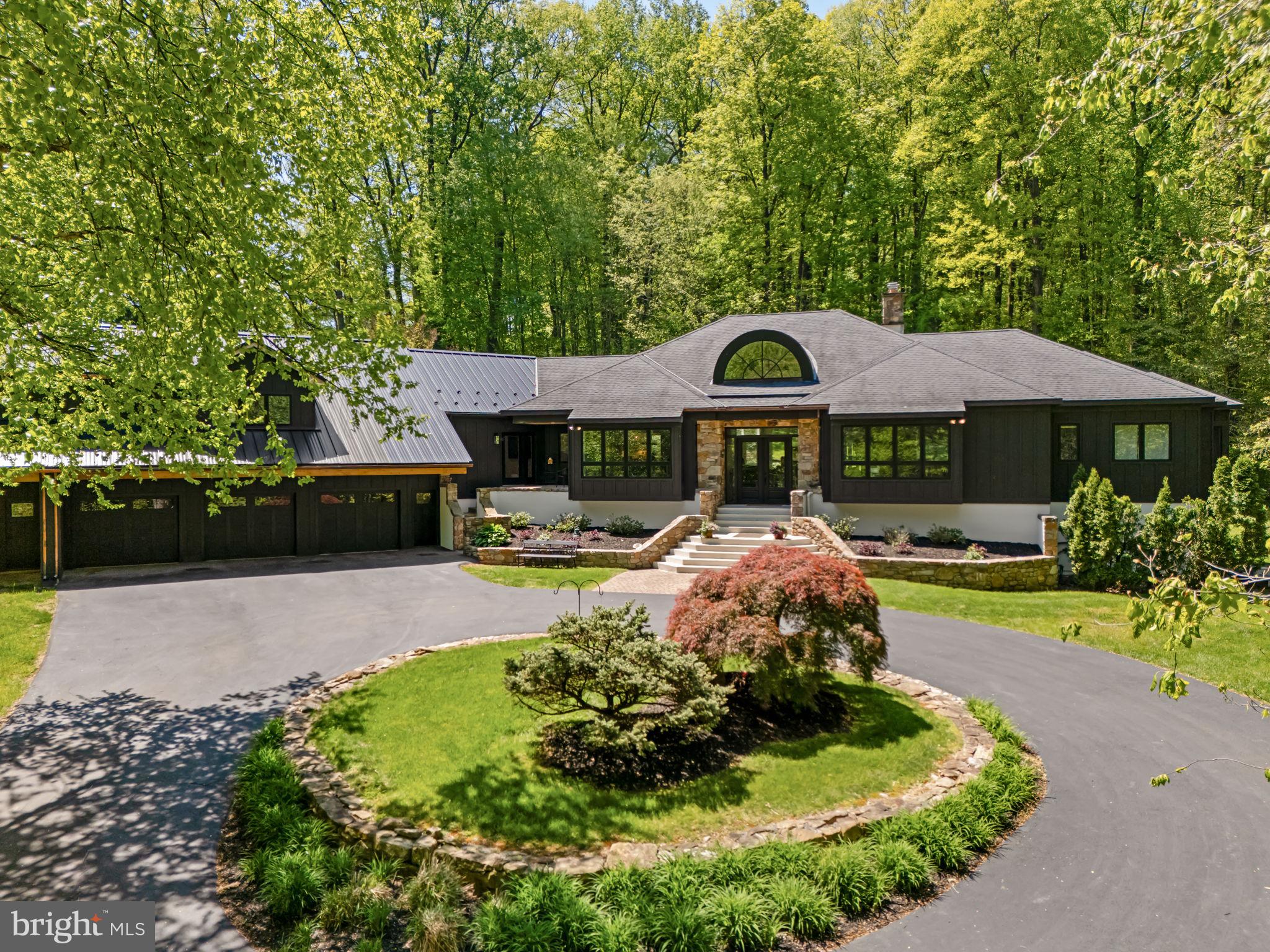 Some properties are simply a home. This one is something more, a rare opportunity for multi-generational living, a private homestead, or a flexible family estate, all wrapped into one extraordinary Chester County property.

Set at the very end of a long, semi-private approach, 2800 Horseshoe Trail reveals itself with quiet intention—where architecture, landscape, and privacy converge. A sweeping circular drive introduces the home’s striking exterior, newly finished in James Hardie board-and-batten siding with refined stone accents. Beyond, 8.5 acres unfold in a rare, uninterrupted expanse overlooking Birchrun Creek, creating a natural buffer of tranquility that feels worlds away.

Inside, the architecture becomes the experience. The dramatic octagonal Great Room anchors the home with soaring cathedral ceilings, a statement fireplace, and a full wall of windows that dissolve the boundary between indoors and the surrounding landscape. Light moves effortlessly through the space, highlighting custom built-ins and the home’s intentional design—crafted for both grand entertaining and quiet moments.

The primary suite is a private retreat in every sense—designed with a spa-level sensibility, featuring heated floors, a cast iron clawfoot tub, quartz surfaces, a window-lined walk-in shower, and a bespoke dressing area complete with walk-in and cedar closets. The kitchen balances beauty and function with quartz countertops, hardwood floors, a walk-in pantry, and a sunlit breakfast space that opens to a thoughtfully designed hardscape patio.

What truly sets this property apart is its rare ability to offer both connection and independence. The main residence flows seamlessly while providing distinct living zones, including additional bedrooms, a secondary living space, and its own laundry—creating flexibility without compromise.

A substantial, fully integrated addition expands the possibilities even further. Designed with intention and privacy, it features its own entrance, a kitchenette with custom cabinetry and quartz finishes, an open living area, a private bedroom suite, and multiple French doors that invite in natural light. Whether for extended family, long-term guests, or a live-in arrangement, it lives effortlessly as its own residence while remaining connected to the whole.

The lower level continues this theme of versatility, offering a finished retreat complete with a full bath, mirrored wet bar, lounge or fitness area, bedroom, and additional unfinished space with exterior access—ideal for evolving needs.

With approximately 7,500 square feet of living space, the home unfolds across multiple thoughtfully designed environments—four bedrooms, an office, den, multiple living areas, a kitchens and kitchenette, and layered indoor-outdoor living—all set within a landscape defined by privacy, natural beauty, and neighboring preserved land and equestrian estates.

This is more than a home.

It is a private estate—architecturally distinct, quietly luxurious, and designed for the way life is truly lived.
