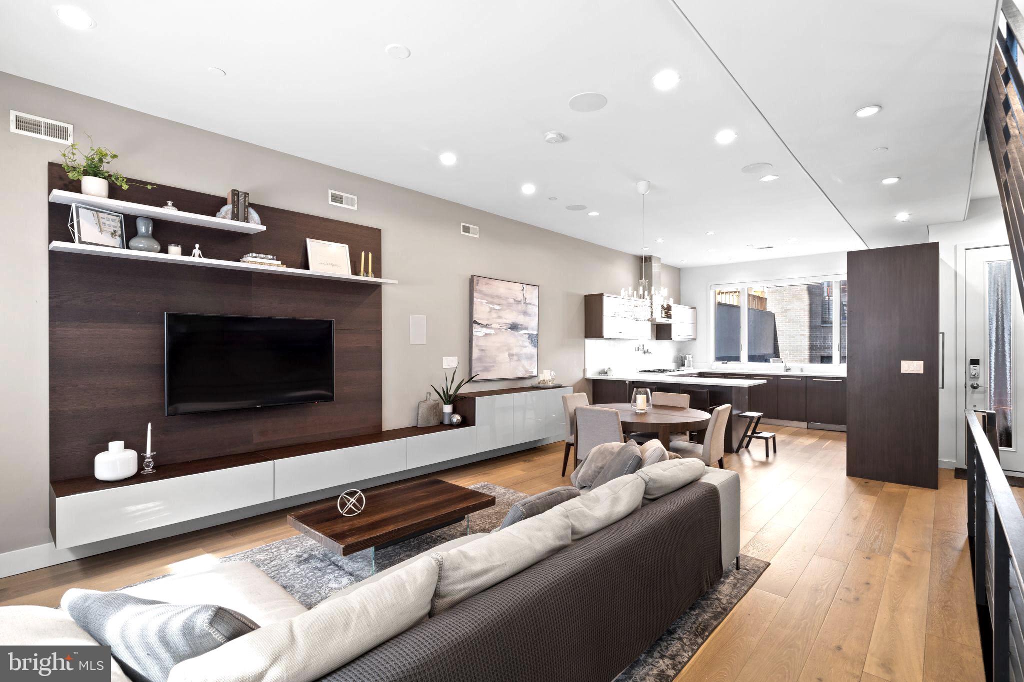 Introducing 204 W Laurel Street, a luxury residence in the exclusive Laurel Court community in Northern Liberties—just steps from Liberties Lands Park, The Piazza, and top dining, markets, and nightlife. This three-story townhome offers nearly 3,000 Sq Ft, with 3 bedrooms, 3 full baths, 1 half bath, private parking, and multiple outdoor spaces, including a rear patio with gas line, primary suite terrace, and a large roof deck with gas line and skyline views. Inside, the home features custom European-style wood veneer cabinetry, Silestone quartz countertops, porcelanosa kitchen and bath design, and a custom tile backsplash. Additionally - a full suite of panel-ready Thermador appliances, including a 36” gas cooktop, integrated refrigerator and dishwasher, convection oven and microwave, and pot filler. Main living areas boast 3/4” hardwood floors, oversized Andersen 400 windows, a gas fireplace, motorized shade wiring, and 5.1 surround sound prewiring. The open-riser staircase is a design focal point, built with solid wood treads, steel stringer, and custom metal railings. The primary suite includes a large walk-in closet system, floor-to-ceiling windows, and a spa-like bath with freestanding soaking tub, 6’x4’ rain shower with body sprays and hand shower, custom floating double vanity, and wall-mounted European toilet. The finished basement includes heated porcelain tile floors, a full bath, and a large storage/flex space ideal for a gym or guest suite. A pilothouse wet bar with sink and wine fridge offers convenient access to the roof deck. Additional highlights: Dual-zone high-efficiency HVAC, 200 Amp electric, CAT6 wiring + video intercom system, Prewired for full home automation, TREX composite decking, 20-year certified TPO roof, NuHeat radiant heating in basement floors, 10’ ceilings on living and primary levels. A rare blend of thoughtful architecture, custom finishes, and prime location. 204 W Laurel Street delivers high-end living in one of Philadelphia’s most coveted neighborhoods.