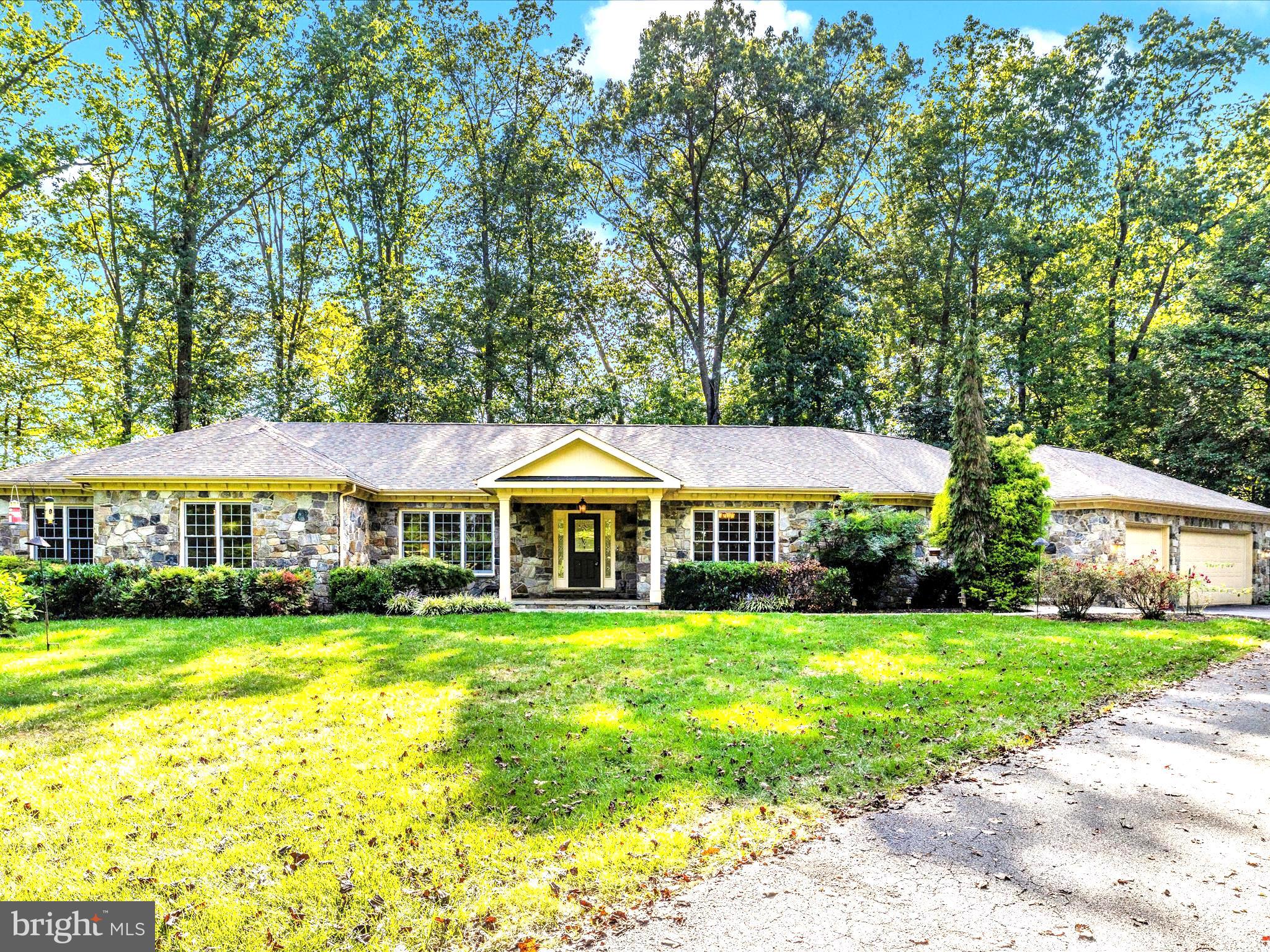 Luxury 1st Floor living in URBANA Schools -  Stunning in all directions from the brand new granite countertops throughout, freshly refinished showroom floors, peacefully desirable Sherman WIlliams neutral paint throughout.  Welcome home to 11589 - A Nor Ray where a first floor handicapped accessible primary suite with propane fireplace and dual walk in closets await the most discerning of buyers.  Office space and four additional bedrooms with en suite bathrooms, and powder rooms for entertaining guests and 2 family rooms await.  Anchoring the shared space is a field stone hearth and fireplace featuring colors of soft blues and hues of grey.  From all windows and in all directions, gorgeous views of mature landscaping, flagstone sitting porches and patios and colorful trees delight.   Newer appliances, under cabinetry lighting and miles of storage with a large walk in pantry hilight the kitchen amid stunning granite counters.  Disposal, dual ovens, a dishwasher, microwave and cooktop with tons of counter space were designed with family and entertaining in mind!   A first floor laundry with organizational cabinetry sits adjacent the kitchen close to the garage entrance, side door, coat closets and large powder room.  A fully sunlit 2nd family room and wet bar allows separate space for entertaining or could be the perfect 2nd primary ensuite if ever needed.  The space is wrapped in glowing windows and has access to fresh air right down to the patio and firepit.   On the lower walkout level is flex office/rec space, additional bedrooms, a full bathroom and a tremendous amount of storage.  On 2 acres of serene private land, you'll find this classic built stone home with incredible features and so much to offer.  Beyond the long paved and sealed driveway is a lighted flag pole, a RV pad with water and electric and a gorgeous sitting porch.  and There is no HOA, no covenants and a cute little chicken house with a lovely storage garage too! There is space for a large detached workshop/garage/pool house and more!