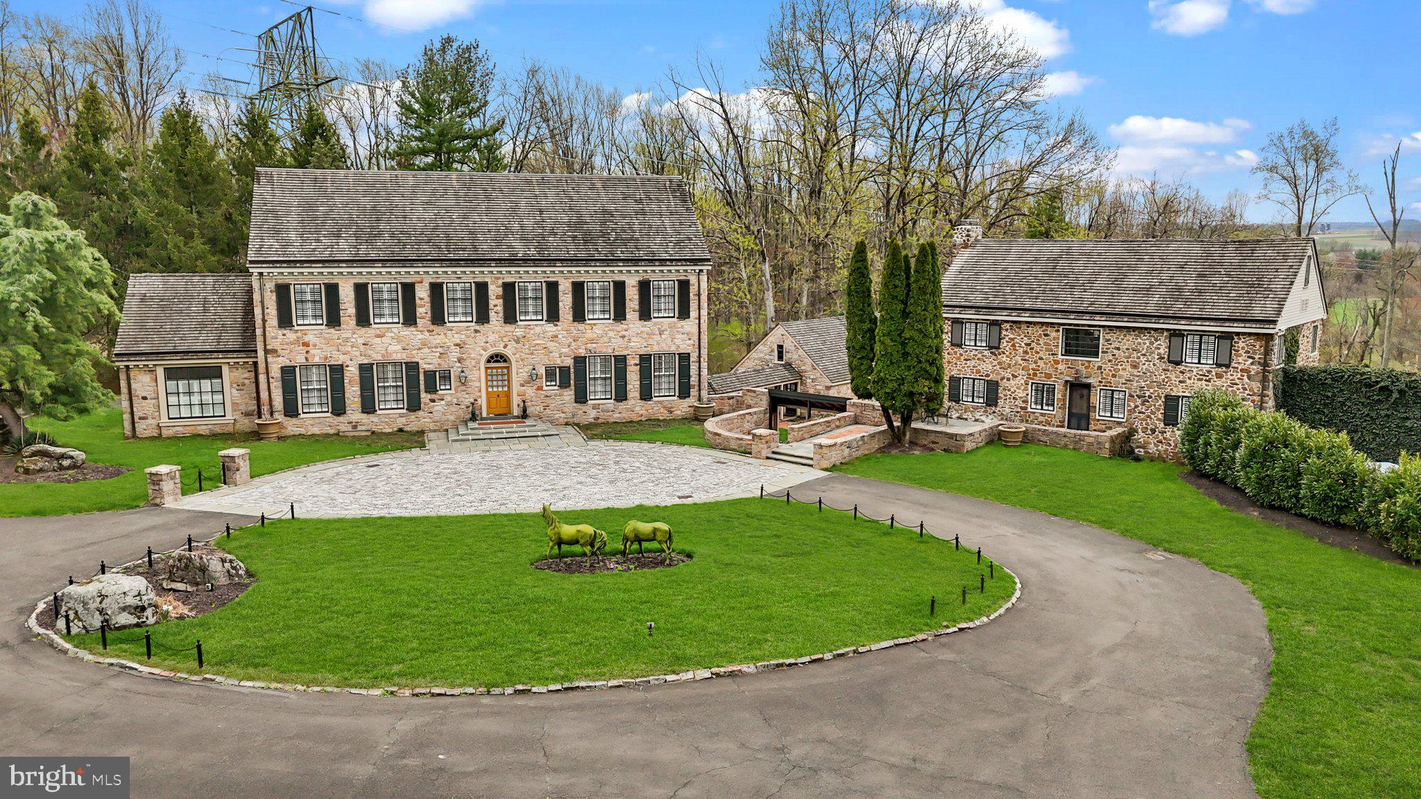 Welcome home to one of New Hope best kept secrets..."Bramingham Estate", located in historic Bucks County, PA. Set on almost 11 acres, this beautifully renovated property consists of multiple structures totaling over 8,000 sq. ft. of living space that offers an uncompromising level of quality, custom finishes and attention to detail with inground pool, lighted tennis court, and bucolic pond. A long, private driveway leads to the exquisite stone manor's main entrance. The grand foyer provides a spacious greeting area and is flanked on the right by a presidential salon...a formal living room with portraits of American presidents! This unique room has plenty of natural light and also features two crystal chandeliers, a massive antique fireplace, a small wet bar, and built-in cabinetry. To the left of the foyer, on the other side of this magnificent home is the library, gourmet chef’s kitchen and a stunning conservatory with a 2nd wet bar, custom cabinetry, and coffee station. (This space could easily be used as a dining area as well.) The working chef's kitchen features a Wolf range with 2 ovens, Sub-zero appliances, a 3rd steam oven, large working island and a gorgeous La Cornue wall mounted rotisserie. Skylights and windows make this kitchen bright and inviting and the wall of display cabinetry is the perfect setting for beautiful china. The library is a warm and inviting main floor study that can serve as a media room, home office or simply a peaceful respite to relax with a book. A beautifully constructed curving staircase leads up to the primary suite with a large bath and 2 walk-in closets, as well as a circular staircase up to a loft retreat.  A second bedroom and 2 additional rooms, currently being used as an office and study, round out the upper level of this home. The lower level boasts a wine cellar, sauna, full bath, laundry and a spacious family and entertainment area with murphy bed opening to the outside fountain and gardens and 3+ car garage with finished space above. This impressive stone manor house sits prominently in the foreground adjacent to a charming 5 bedroom, 4 bathroom stone guest house your guests will never want to leave.  Renovated to have a more casual rustic feel, the main level has fieldstone fireplace, new kitchen with induction range, and 1st floor bedroom and full bath. The 2nd floor has 2 ensuite bedrooms and there are 2 additional bedrooms and a shared bath on the 3rd floor—plenty of room for in-laws, visiting family and friends, au pairs, or as a true home office. Both the main residence and the guest house look out to expansive lawns and spectacular views. The grounds have been well-maintained with specimen plantings, brick and stone walks, sculptures, large planters, fountain and stone ruins for al fresco dining. Brick paths lead to the spa-like concrete pool and a large patio space that encourages outdoor entertaining. The pool house contains his and her changing rooms, showers, bathrooms, a full caretaker or au pair suite and a small caretaker’s kitchen. Bramingham Estate offers privacy and the evolution and design of structures and natural settings that grow organically from each other while still being close to great shopping and delicious restaurants in nearby Peddler’s Village and downtown New Hope, in the award winning New Hope-Solebury School District. The property is protected by a state-of-the-art security system.  Note: The size of the Manor Home is approximately 5,175 sq. ft., Guest Cottage is about 2,290 sq. ft. and the Pool House is roughly 750 sq. ft. Perfect for a family compound!
