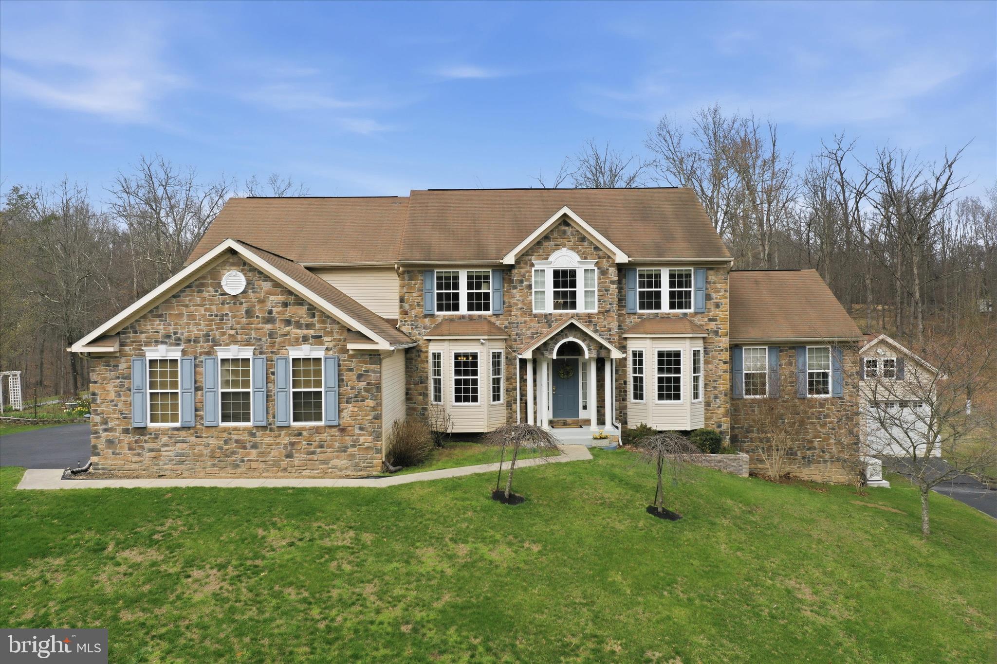 Welcome to Sherwood Forest—where space, privacy, and everyday comfort come together on 2.14 level acres. With over 5,000 square feet of living space, this impressive colonial offers room to live, work, and entertain with ease.  The main level features a grand foyer with hardwood floors, formal dining and parlor spaces, and a sun-filled family room that invites you to relax and unwind. The kitchen is designed for gathering, complete with gas cooktop, bar seating, pantry, and a bright breakfast area overlooking the backyard. A private office, laundry room, and half bath add everyday convenience.  Upstairs, the spacious primary suite offers a peaceful retreat with a sitting area, jetted tub, walk-in shower, and generous closet space. Three additional bedrooms provide flexibility, including one with a private bath.  The fully finished basement expands your options with a second kitchen, large family room with fireplace, office, exercise space, and abundant storage—ideal for guests, multi-generational living, or entertaining.  Outside, enjoy a fenced patio area perfect for evenings by the fire, along with open, level acreage ready for recreation or relaxation. With an attached three-car garage plus a detached garage with loft, there’s no shortage of space for vehicles, hobbies, or storage.  Conveniently located near Martinsburg, Hagerstown, and Winchester, with access to the MARC train for commuting—this home offers the perfect blend of space, function, and location.