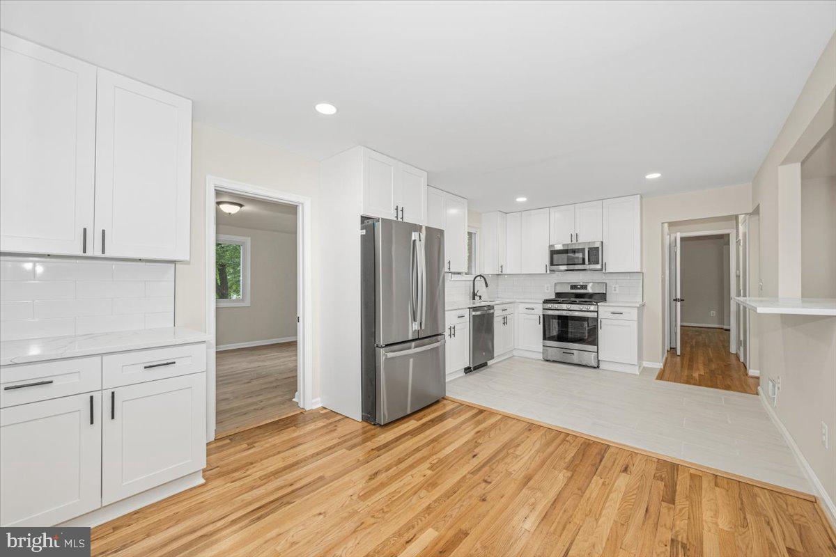Welcome to this charming over sized and fully renovated Cape Cod "King" model in the heart of sought after Kings Park community. Surrounded by mature trees and situated on a peaceful corner lot. The home has recently been updated from top to bottom with high end materials/fixtures. Enjoy the open concept from the kitchen to the family room with a wood burning fireplace and the refinished hardwood floors throughout the house. The kitchen and bathrooms are tastefully updated. Features an incredible layout with 6 bedrooms and 3 full baths, including two oversized bedrooms on the main-level with the primary bedroom having its own bath. The finished basement includes a rec area, large bedroom, with a full bathroom, and a laundry room which includes a brand new washer dryer, also a walk out to the updated patio and backyard. The third level offers 3 good sized bedrooms and a full bathroom. The entire home has been freshly painted and offers great storage as well. Enjoy outdoor living on the large deck off the dining room overlooking the spacious .37-acre landscaped lot perfect for relaxing, entertaining, or creating your dream outdoor space. A paved driveway plus convenient street parking offer ample parking options. Location truly shines with close proximity to Kings Park Elementary, Kings Park, the local library, shopping, dining, and everyday conveniences. Don't miss this one!
