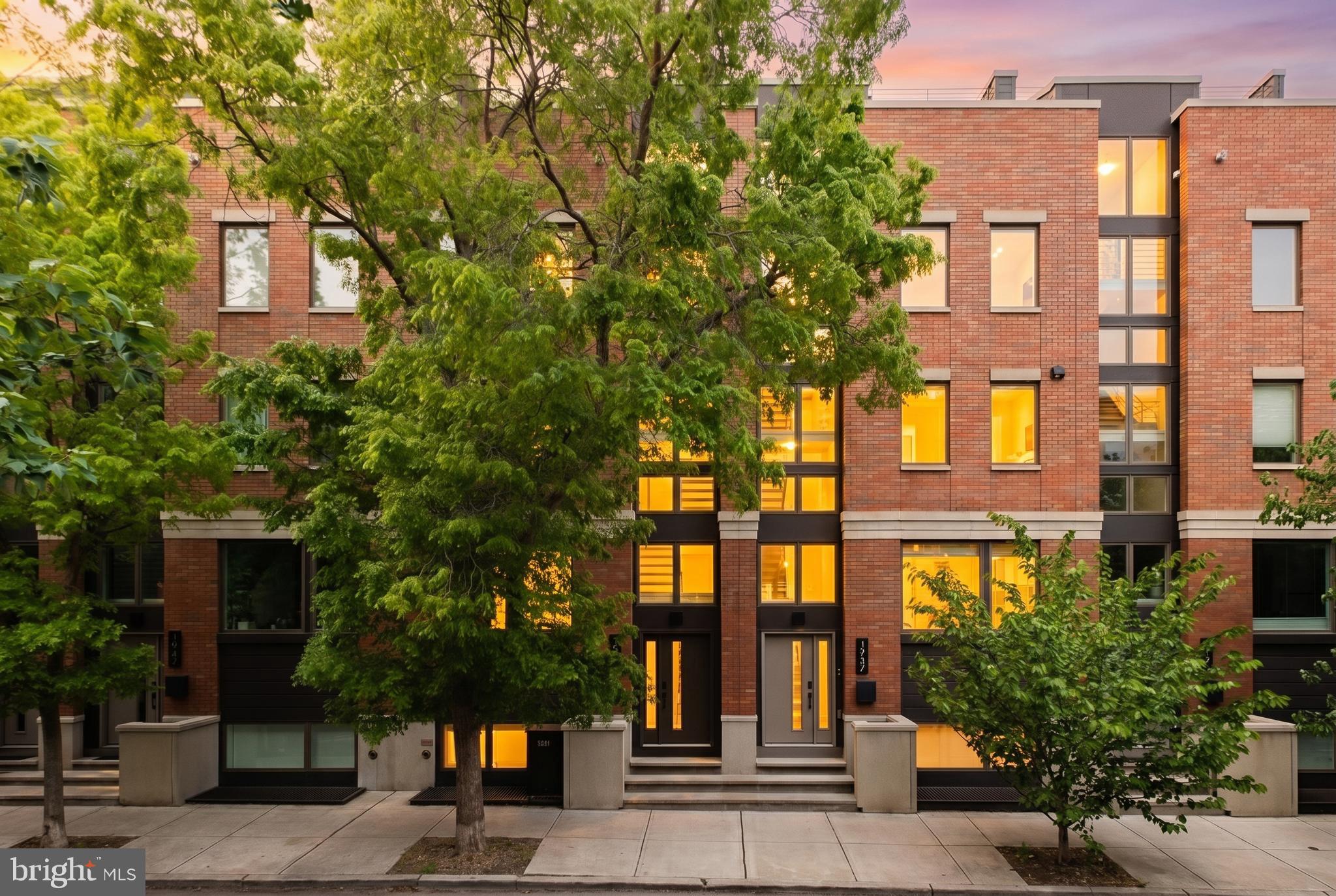 Rising above the surrounding streetscape, this striking townhome is among the tallest residential homes in the neighborhood and offers an extraordinary blend of luxury, scale, and modern city living.

1939 Christian Street features two-car parking private and gated entry, a private five-stop elevator, soaring 10+ foot ceilings, three distinct outdoor living spaces, and sweeping skyline views from one of the highest residential roof decks.

Upon entry, you are welcomed by a dramatic floating metal staircase framed by oversized picture windows that flood the home with natural light across all four levels. The main living floor was thoughtfully designed for both everyday living and entertainment, featuring a stunning chef’s kitchen with Wolf and Sub-Zero appliances, quartz countertops and backsplash, and custom high-end cabinetry. The adjoining dining and living areas center around a sleek gas fireplace and well-appointed powder room and seamlessly connect to an expansive private terrace through oversized sliding glass doors, complete with a dedicated grill and mature plantings.

The second floor offers two generously sized bedrooms with ample closet space, a beautifully appointed full bathroom with designer-selected finishes, and a dedicated laundry room with graphite front-load washer and dryer units. Whether by staircase or elevator, the experience throughout the home is one of effortless comfort and sophistication.

Occupying the entire third floor, the primary suite is a true private retreat featuring spacious walk-in closets and a spa-inspired five-piece bath with a freestanding soaking tub, oversized glass-enclosed shower, body sprays, handheld fixtures, and radiant heated tile floors.

The fourth-floor bonus lounge elevates the entertaining experience even further with a wet bar, powder room, and sliding glass doors opening to a front terrace overlooking the historic spires of St. Charles Borromeo Church. Above, the expansive rooftop deck delivers breathtaking 360-degree city views — an extraordinary setting for dining, entertaining, or simply enjoying the Philadelphia skyline under the stars.

The fully finished lower-level features 10-foot ceilings, a full bathroom, and flexible living space ideal for a home office, guest suite, gym, or playroom.

Additional luxury amenities include multi-zone heating and cooling systems, smart home features including Ring security and Nest thermostats, tesla charging station, a Sauna, Lutron for lighting and electric shades throughout and designer finishes curated throughout the residence.

This home combines architectural presence, luxury craftsmanship, and an unbeatable location into one of Graduate Hospital’s most compelling neighborhoods. Five and a half years remaining on the tax abatement.