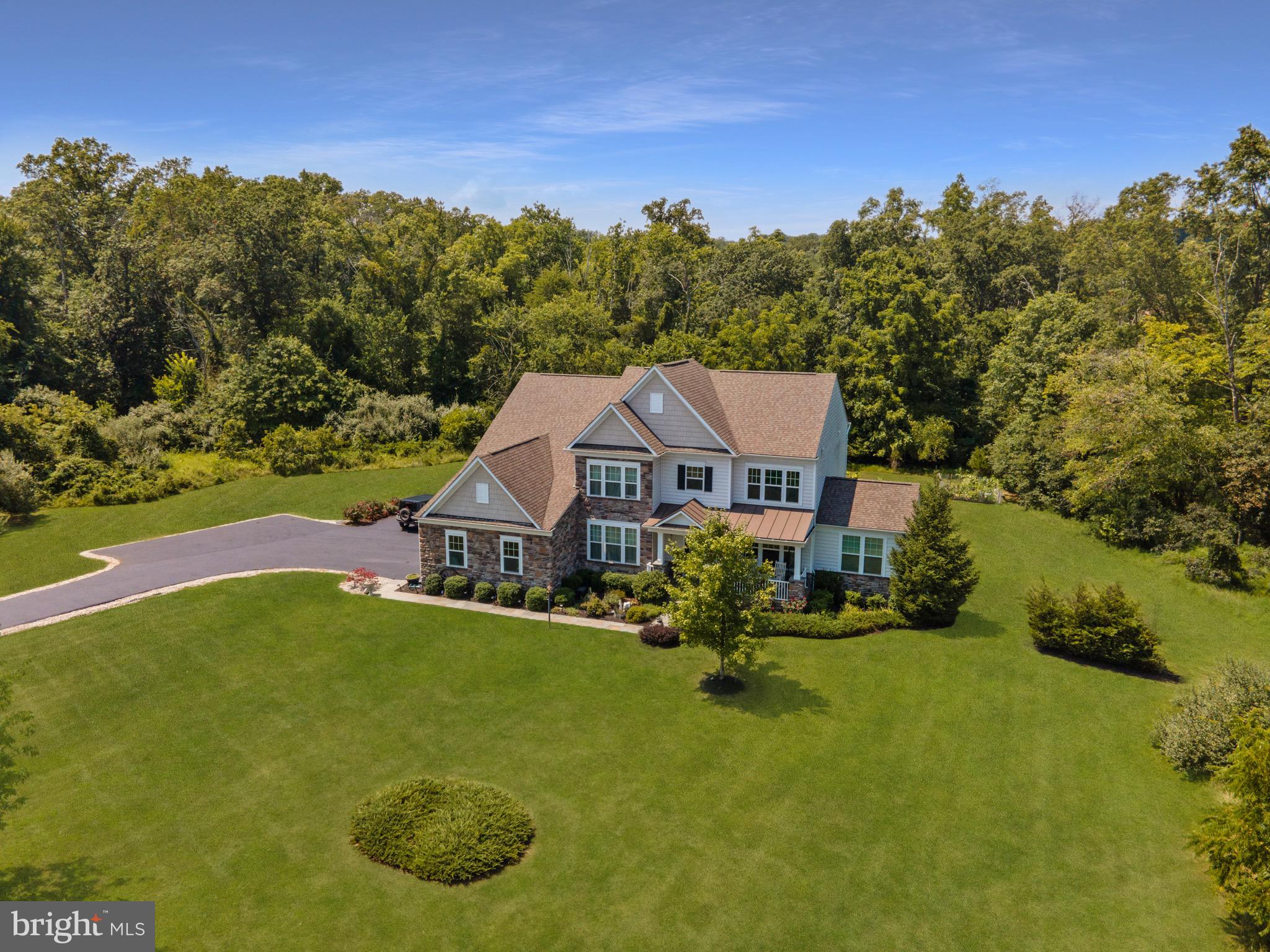 Unbelievable opportunity to own  6,500 finished square feet on your own majestic 100-acre conservancy lot in beautiful Greene Mill Preserve.  Enjoy the incredible beauty this property has to offer including a 4+acre pond well stocked with fishes that you could take your canoe or paddle board on; a private trail to meander through; a gorgeous double story historic fireplace circa 1857 from a farmer who previously owned the land; a field blanketed in daffodils that blooms each spring and are over 160 years old; a babbling water stream; Cherry Blossom trees in the front yard; banana trees and garden in the back yard; and acres upon acres of private wooded land. This Stanley Martin built 'Sutton' model with three-car side load garage boasts an elegant stone elevation and welcoming covered front porch with metal roof. This open floor plan home has left no detail unattended including wide plank hardwood floors throughout most of main level; brand new carpet in 08/2021 Bedrooms and stairwell; elegant moldings, chair rails + shadow boxing throughout; main level Bedroom + full Bathroom (added in 2020); Gourmet Kitchen that will fulfill all of your entertaining and home chef needs with an oversized center island + breakfast bar, stainless steel appliances and gas cooking, Breakfast Room and Morning Room with vaulted ceilings that offer access to the outdoors where you can extend your living space to the Trex deck (2016), paver patio and built-in firepit (both 2017) surrounded by the privacy of your treed conservancy lot; Family Room off the Kitchen with a cozy, floor-to-ceiling stone, gas fireplace; Primary Bedroom on upper level with a private Sitting Room, spacious walk-in-closet, and a Primary En-Suite Bathroom with soaking tub, walk-in rain shower,  dual sink vanities, and water closet; upper level also hosts three additional Bedrooms each with walk in closets and serviced by two additional full Bathrooms; fabulous lower level finished in 2020 will leave you in awe with four new egress windows, waterproof luxury vinyl plank wood-look flooring, handsome bar with granite counters beverage fridge and wet sink, Media Room with projector and seven built-in speakers, open and spacious Game and Rec Rooms, Guest Room serviced by dual entry full Bath, plus a full apartment with it's own private outdoor access and exquisite details throughout the full Kitchen with Quartz counters and stainless appliances, Den and Dining area, Laundry closet (with full size washer/dryer), Bedroom and full Bathroom! Additional outstanding features include built-in radon fan, two sump pumps with battery backup, interior/exterior security cameras and motion/crash sensors on windows, expanded asphalt driveway (2019), modern sensor automated faucets in lower level, new garbage disposal and Kitchen faucet (2021), two hot water heaters ( 2016 and 2018), wired for Verizon Fios. In additional to everything this spectacular property holds in store for you, you will also be able to enjoy all of the amenities and events that Greene Mill Preserve provides its residents including pools, soccer fields, basketball courts, tot lots, a butterfly garden, nature trails and community clubhouse. Located just a short drive to downtown Leesburg, Loudoun County Wine and Hunt Country, shopping at the Leesburg Outlets/One Loudoun/Brambleton Town Center, access to commuter routes (Dulles Green Way, Dulles Toll Road, Routes 50/7/28) and minutes to Dulles Airport, and so much more. This exceptional property is waiting for you to call it your new home!