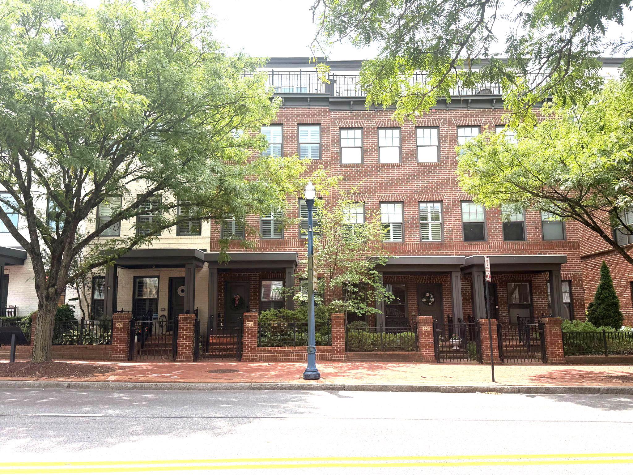 This gorgeous townhome nestled in the sought-after community of Uptown at Murray Hill, in the heart of downtown Annapolis' West Street Arts District and just steps away from restaurants, pubs, galleries and boutiques. A classic brick façade and covered front porch overlook a charming city garden. Inside, the home is professionally decorated with elegant Pottery Barn furnishings and thoughtfully curated finishes throughout. The entry level features a flex space with French doors—ideal for guests, a home office, or bedroom—along with a convenient powder room. Upstairs, the main living level showcases rich hardwood flooring and an open, light-filled layout perfect for everyday living and entertaining. The bright kitchen is a true centerpiece, complete with granite countertops, stainless steel appliances, a pantry, and a breakfast counter with seating beneath stylish pendant lighting. A sliding glass door opens to the balcony, extending your living space outdoors for grilling. The kitchen flows seamlessly into the dining area highlighted by a designer chandelier, and onward to the inviting living room with a cozy gas fireplace. The primary suite offers a peaceful retreat with luxury vinyl plank flooring, a spacious California-style walk-in closet, and a beautifully appointed ensuite bath featuring dual vanities, generous counter and cabinet space, and a glass-enclosed step-in shower with built-in bench. A large guest bedroom and a hall bath with tub/shower provide comfortable accommodations for family or visitors. The top floor adds exceptional versatility with a game room and lounge area, complete with a wet/dry bar, powder room, and direct access to a private deck—perfect for entertaining or relaxing evenings at home. Additional highlights include a garage and off-street parking. Ideally located with easy access to Rt. 50, Navy–Marine Corps Memorial Stadium, the United States Naval Academy, the Severn River, and all the shops, dining, and waterfront charm of Annapolis, this exceptional home offers the very best of Annapolis living.
