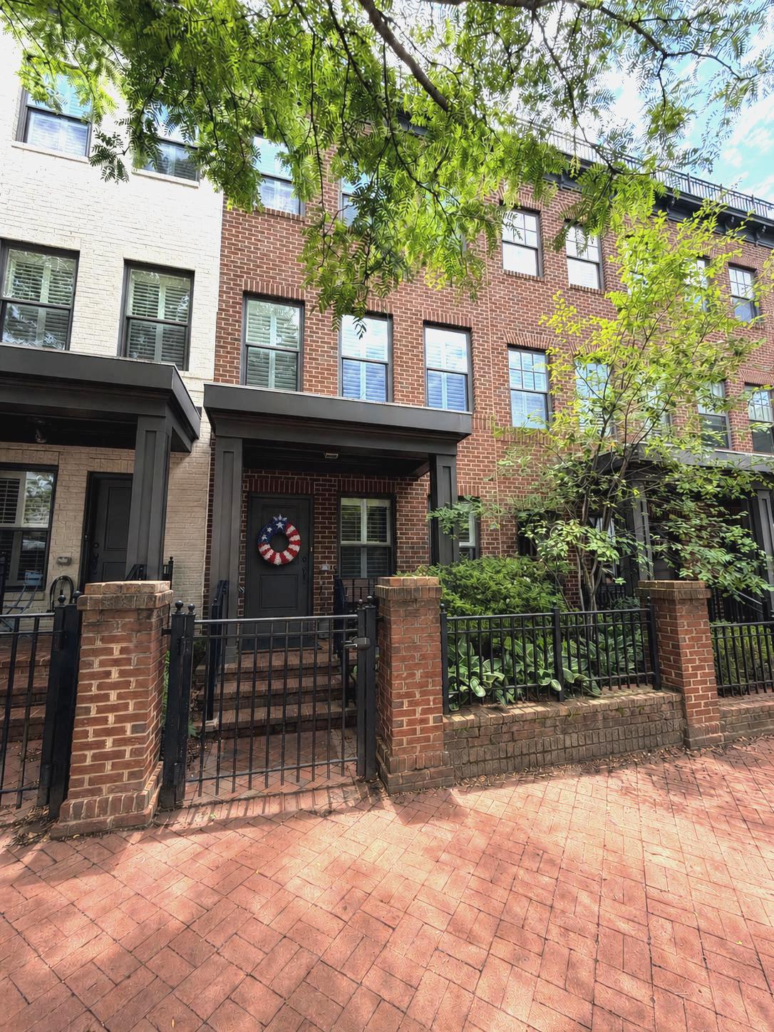 This gorgeous townhome nestled in the sought-after community of Uptown at Murray Hill, in the heart of downtown Annapolis' West Street Arts District and just steps away from restaurants, pubs, galleries and boutiques. A classic brick façade and covered front porch overlook a charming city garden. Inside, the home is professionally decorated with elegant Pottery Barn furnishings and thoughtfully curated finishes throughout. The entry level features a flex space with French doors—ideal for guests, a home office, or bedroom—along with a convenient powder room. Upstairs, the main living level showcases rich hardwood flooring and an open, light-filled layout perfect for everyday living and entertaining. The bright kitchen is a true centerpiece, complete with granite countertops, stainless steel appliances, a pantry, and a breakfast counter with seating beneath stylish pendant lighting. A sliding glass door opens to the balcony, extending your living space outdoors for grilling. The kitchen flows seamlessly into the dining area highlighted by a designer chandelier, and onward to the inviting living room with a cozy gas fireplace. The primary suite offers a peaceful retreat with luxury vinyl plank flooring, a spacious California-style walk-in closet, and a beautifully appointed ensuite bath featuring dual vanities, generous counter and cabinet space, and a glass-enclosed step-in shower with built-in bench. A large guest bedroom and a hall bath with tub/shower provide comfortable accommodations for family or visitors. The top floor adds exceptional versatility with a game room and lounge area, complete with a wet/dry bar, powder room, and direct access to a private deck—perfect for entertaining or relaxing evenings at home. Additional highlights include a garage and off-street parking. Ideally located with easy access to Rt. 50, Navy–Marine Corps Memorial Stadium, the United States Naval Academy, the Severn River, and all the shops, dining, and waterfront charm of Annapolis, this exceptional home offers the very best of Annapolis living.