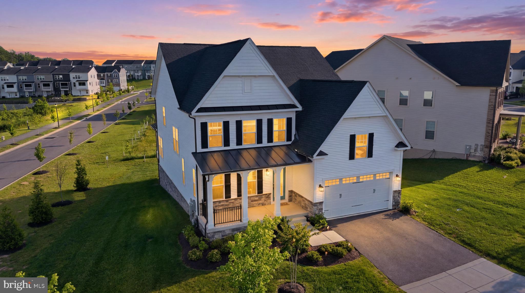 Introducing 7548 Zoe Lane, an exceptional NVHomes Danville masterfully positioned within the prestigious Wellington Farms community, where refined architecture, elevated design, and resort-inspired living come together in perfect harmony. Gracefully situated on a premium Northeast-facing homesite, this exquisite residence captivates from the moment of arrival with its timeless farmhouse-inspired exterior, distinguished by crisp white siding, striking black accents, elegant shutters, a stone water table, lush professional landscaping, an expansive six-car driveway, and a welcoming front porch that evokes the charm of a private country estate. Beyond the front door, a sun-drenched interior unfolds with sophisticated finishes and thoughtfully curated spaces designed for both grand entertaining and intimate daily living. Luxury vinyl plank flooring, fresh designer paint, brand-new carpeting, extensive crown molding, and abundant natural light create an atmosphere of effortless elegance throughout. A gracious foyer introduces a versatile formal space perfectly suited as a distinguished study, formal salon, or elegant dining room. The main level continues with a private guest suite and full bath, offering ideal accommodations for multigenerational living or visiting guests. At the heart of the home lies a remarkable culinary masterpiece—a chef’s kitchen designed to impress the most discerning entertainer. Anchored by a dramatic waterfall island, the space showcases Level 4 Calacatta quartz surfaces, custom 42-inch espresso cabinetry, a designer Level 5 backsplash, premium stainless-steel appliances, double wall ovens, a built-in microwave, walk-in pantry, and a professional-grade gas cooktop beneath a vented hood. The adjoining breakfast room and expansive family room create a seamless gathering space framed by picturesque views and flooded with natural light. Transition effortlessly outdoors to a covered Trex terrace enhanced by a premium RainEscape drainage system, rough-ins for future ceiling fans and ambient lighting, and tranquil views overlooking manicured green space and the community’s resort-caliber amenities—creating an idyllic backdrop for morning coffee, sunset cocktails, and year-round entertaining. Ascending the elegant white oak staircase, the private upper-level sanctuary reveals an extraordinary owner’s retreat accessed through double French doors. This luxurious haven features a tray ceiling, crown molding, recessed lighting, abundant natural light, an expansive walk-in wardrobe, and a spa-caliber bath adorned with quartz-topped dual vanities, a lavish frameless glass shower, a deep soaking Jacuzzi tub, and designer tile selections that evoke the ambiance of a five-star resort. Three additional bedroom suites offer generous proportions, walk-in closets, and direct access to beautifully appointed baths, providing comfort and privacy for family and guests alike. A thoughtfully designed upper-level laundry room with utility sink completes the level. The walkout lower level presents an impressive extension of the home’s living experience, featuring a spacious recreation room, full bath, abundant natural light, and a substantial unfinished area poised for a future home cinema, golf simulator, fitness studio, wine cellar, or custom entertainment lounge. Built in 2023, this residence combines luxury with modern efficiency, featuring a passive radon system, 80-gallon water heater, gas HVAC, and the renowned craftsmanship synonymous with NVHomes. Beyond the home itself, Wellington Farms offers an exceptional lifestyle centered around community and recreation, featuring a resort-style swimming pool, elegant clubhouse, state-of-the-art fitness center, scenic walking and biking trails, beautifully maintained open green spaces, playgrounds, gathering areas, and