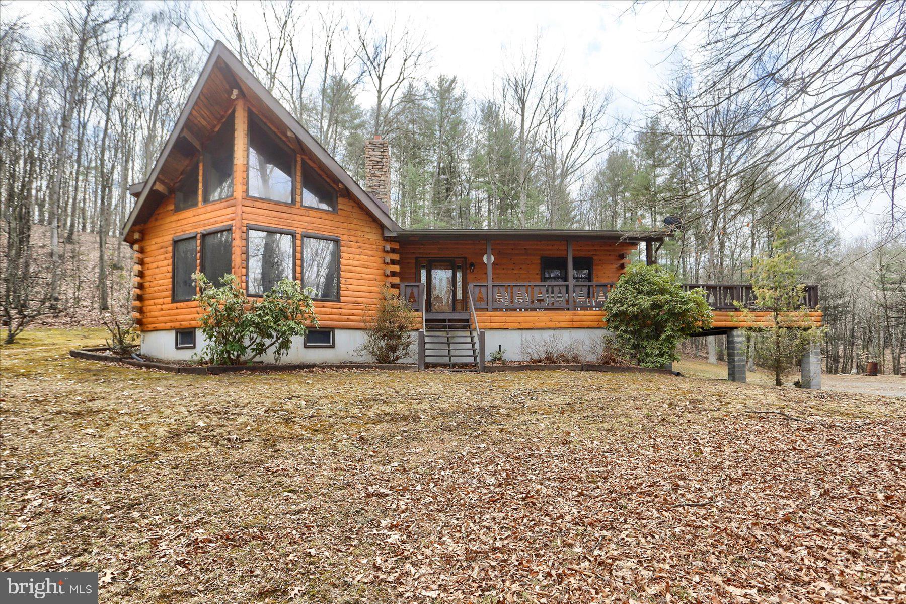 Picture Perfect Cabin IN THE WOODS! 3bed 2 bath log cabin situated on 35 Glorious wooded acres in Huntingdon County!  Close to schools! Great hunting! Huge elevated deck for massive gatherings of all occasions!  Owner suite has a massive soaking tub ! Finished basement with cozy woodstove. Crackling stone fireplace in the living room! Huge massive kitchen with large bar area! Better hurry!
