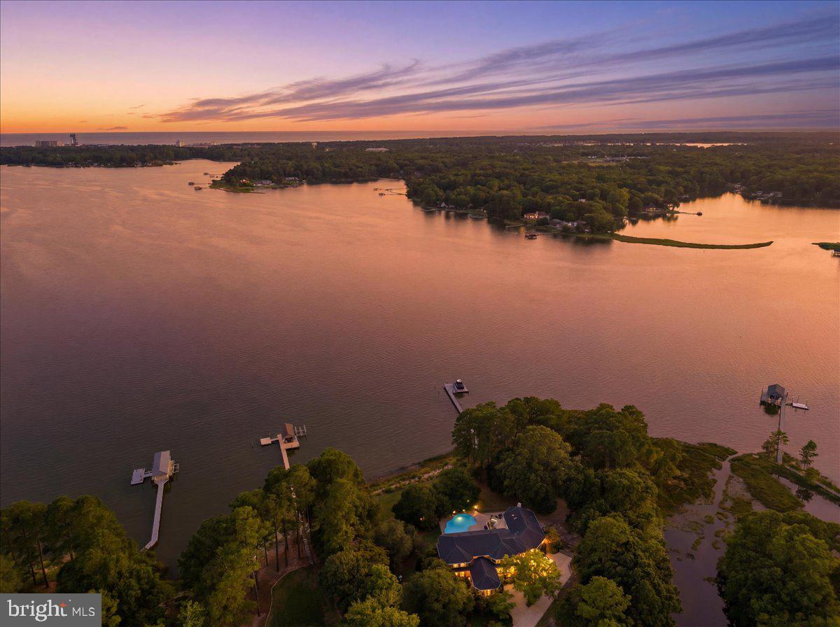 WATERFRONT LUXURY REDEFINED! Set on 3+ private, meticulously maintained acres, this property offers breathtaking, unobstructed views across to the Lesner Bridge. Positioned well behind neighboring homes, the property enjoys a rare sense of privacy, open space, and exclusivity seldom found on the waterfront. Completely transformed through extensive redesign, the home blends timeless elegance with modern luxury. Soaring ceilings, vast water views, a chef's kitchen with Thermador appliances, a butler's pantry with sink and commercial refrigerator, and a spectacular great room with an 85-inch retractable TV and surround sound create an exceptional living and entertaining experience. The primary suite offers a spa-inspired retreat. Outside, enjoy expansive patios, a sprawling lawn to the water's edge, the longest dock on the point, deep-water access at low tide, a 10,000-lb boat lift, dual jet ski lifts, 240V dock power, and a certified, fortified roof. A truly rare waterfront estate!